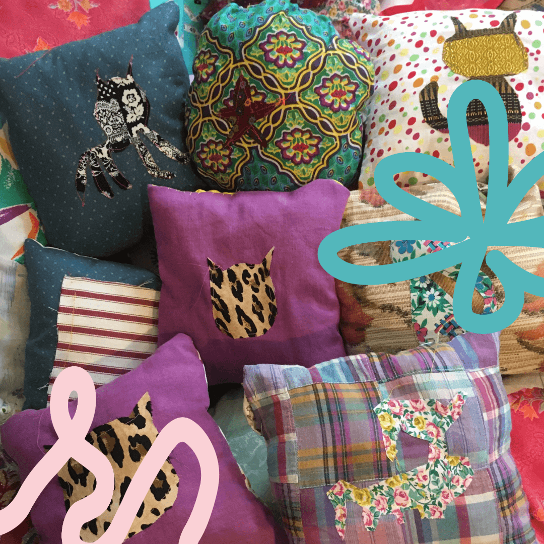 Assorted decorative pillows with various patterns and animal silhouettes, incorporating floral, geometric, and patchwork designs, arranged together. Some pillows have colorful abstract illustrations overlaid on them.