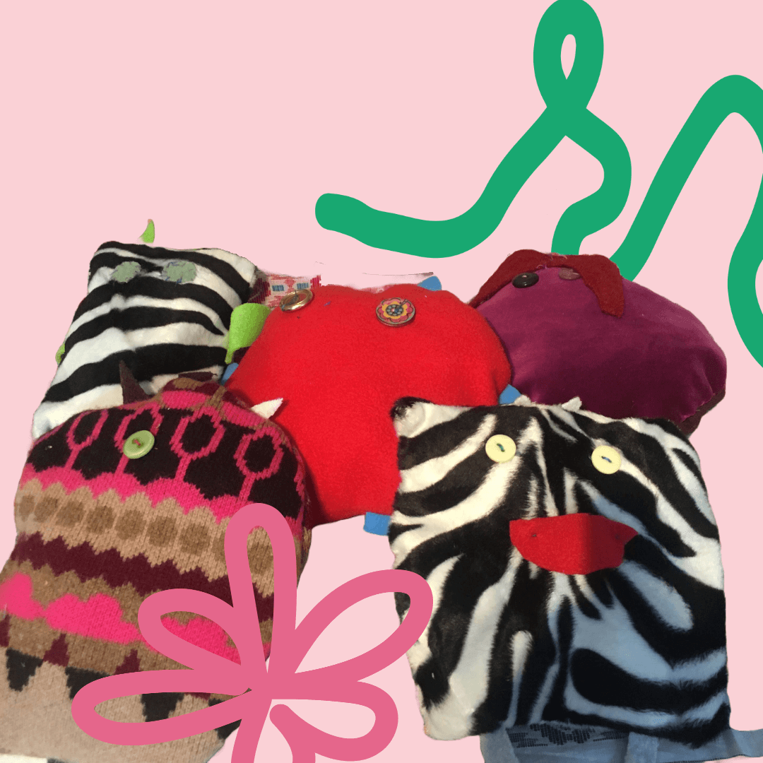 Group of colorful plush pillow characters with button eyes on a pink background, featuring various patterns including zebra stripes and knit designs.