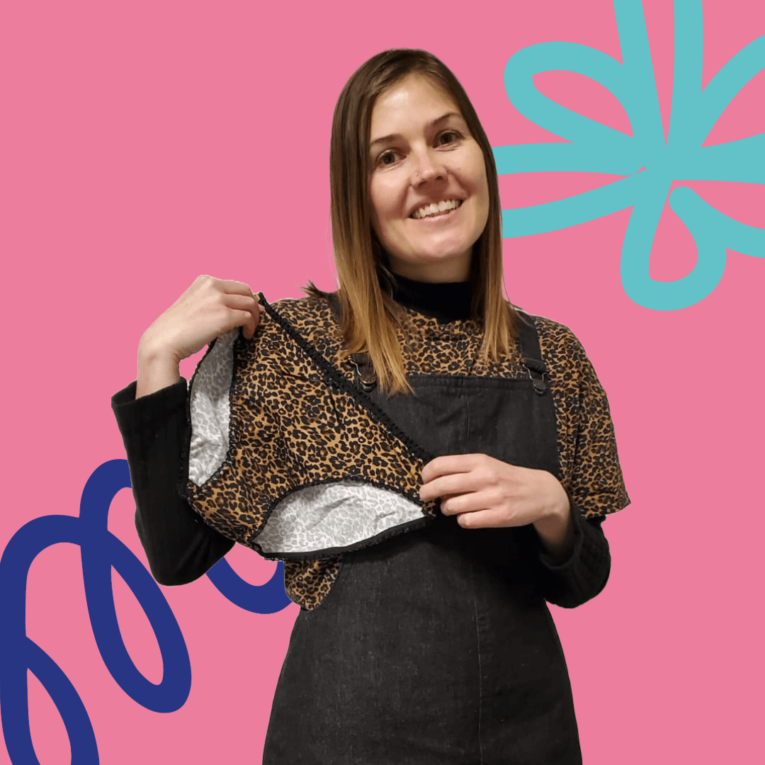 A smiling woman holding up leopard print knickers