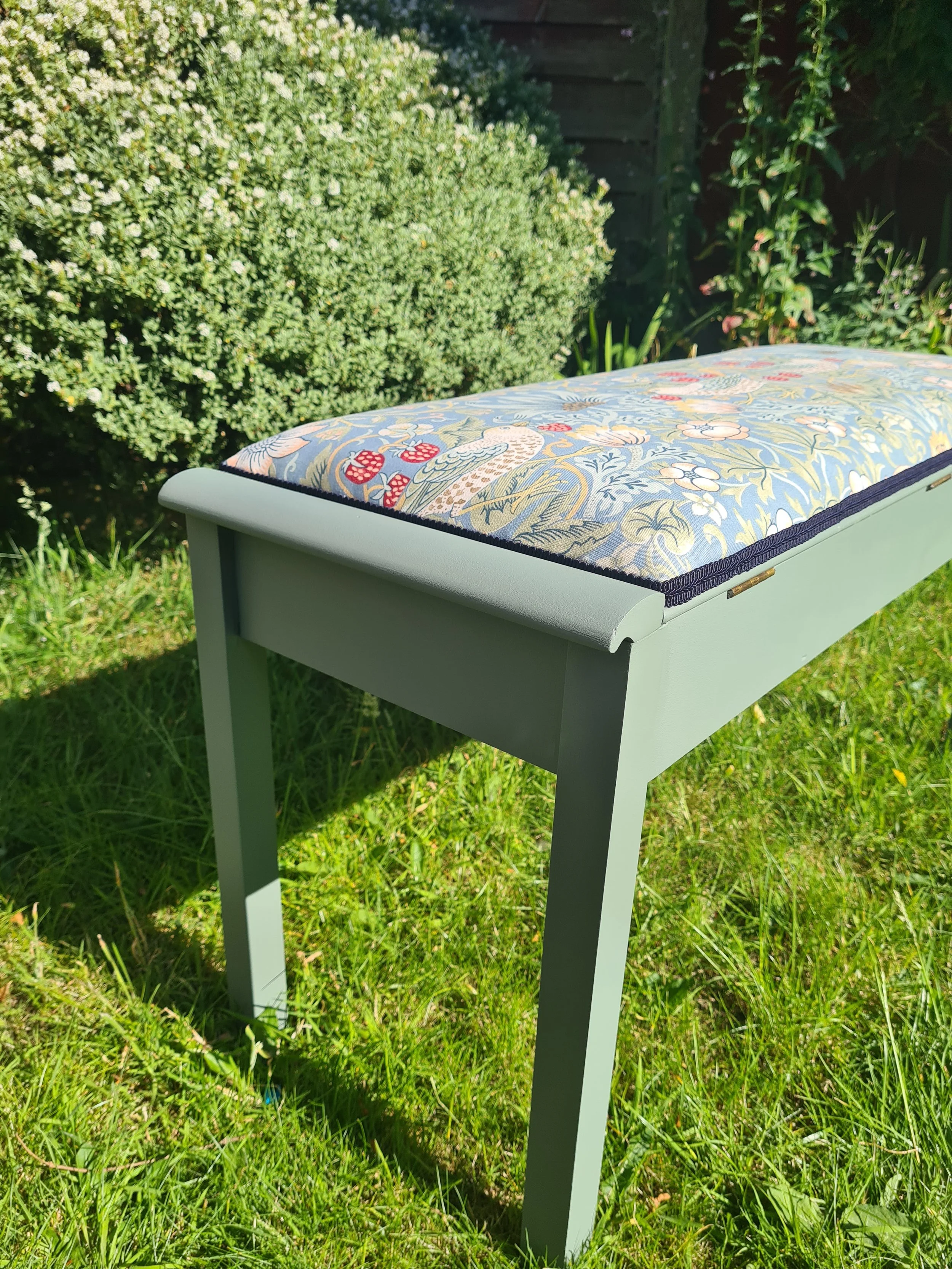 vintage piano stool upcycled and reupholstered in William Morris fabric in garden
