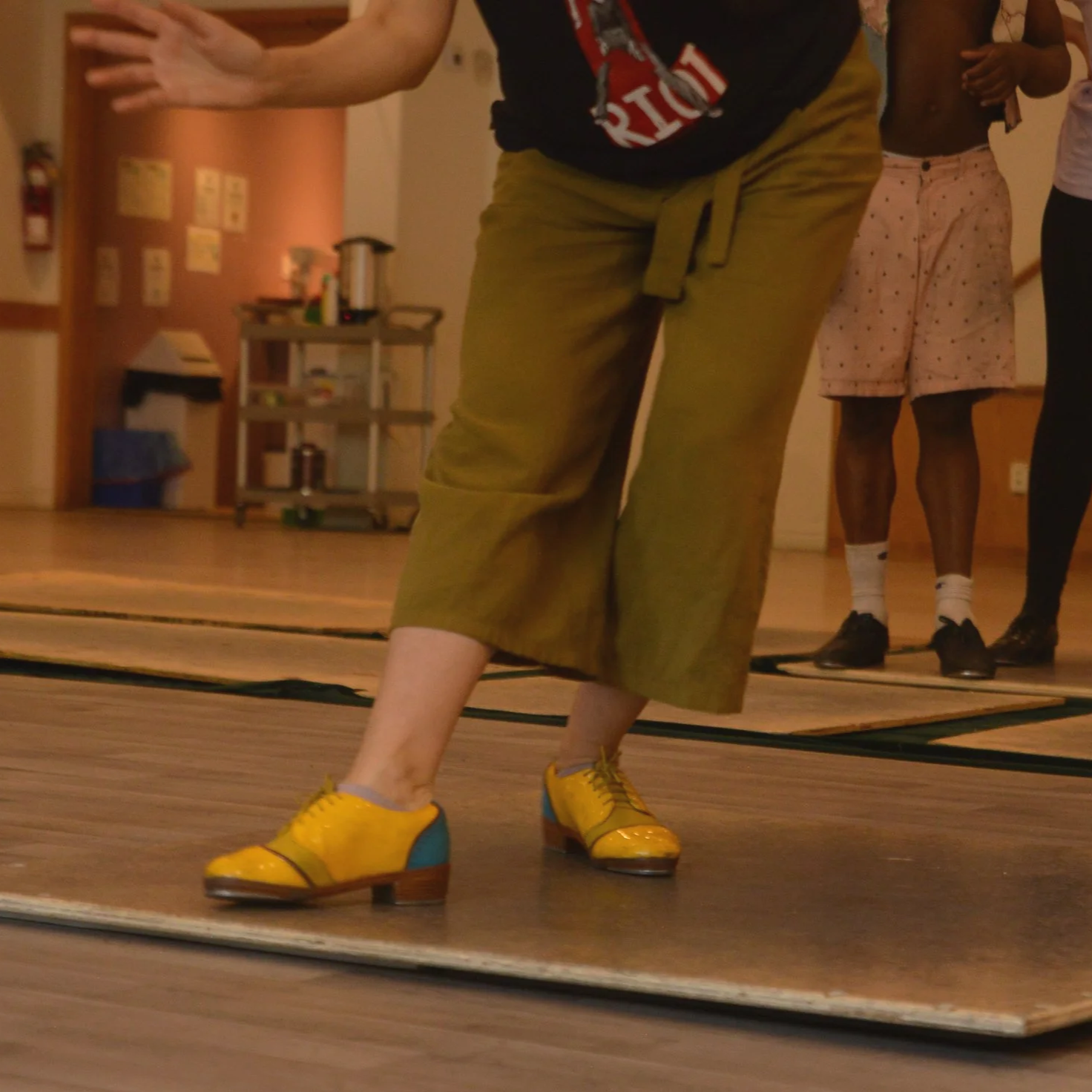 Une personne porte des souliers de claquettes SafShoes sur une planche de tap