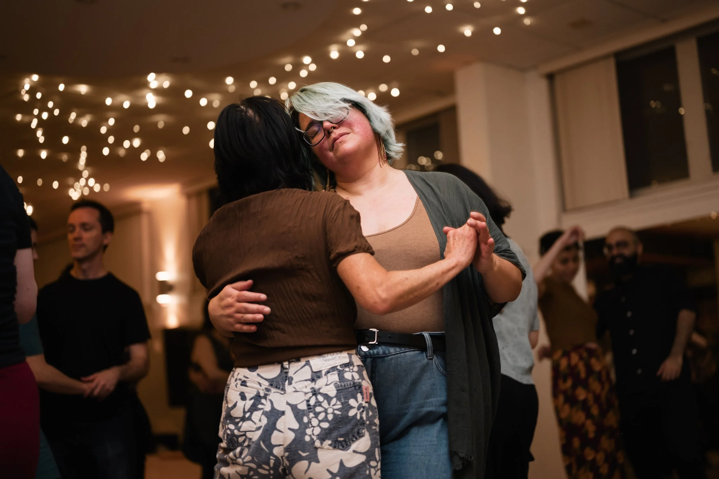 Two women are dancing the blues in a crowded room
