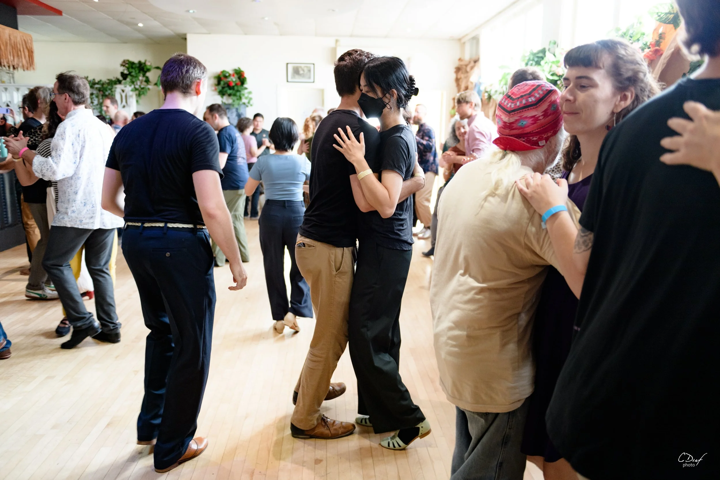 A couple dances the Balboa in a busy room at a social dance