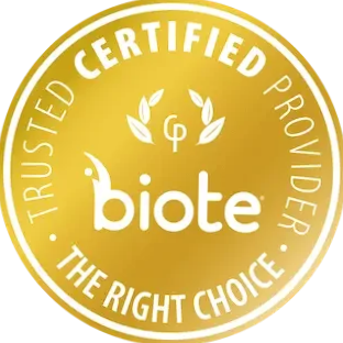 A woman with red hair wearing a white dress with her arms outstretched in a field during sunrise.