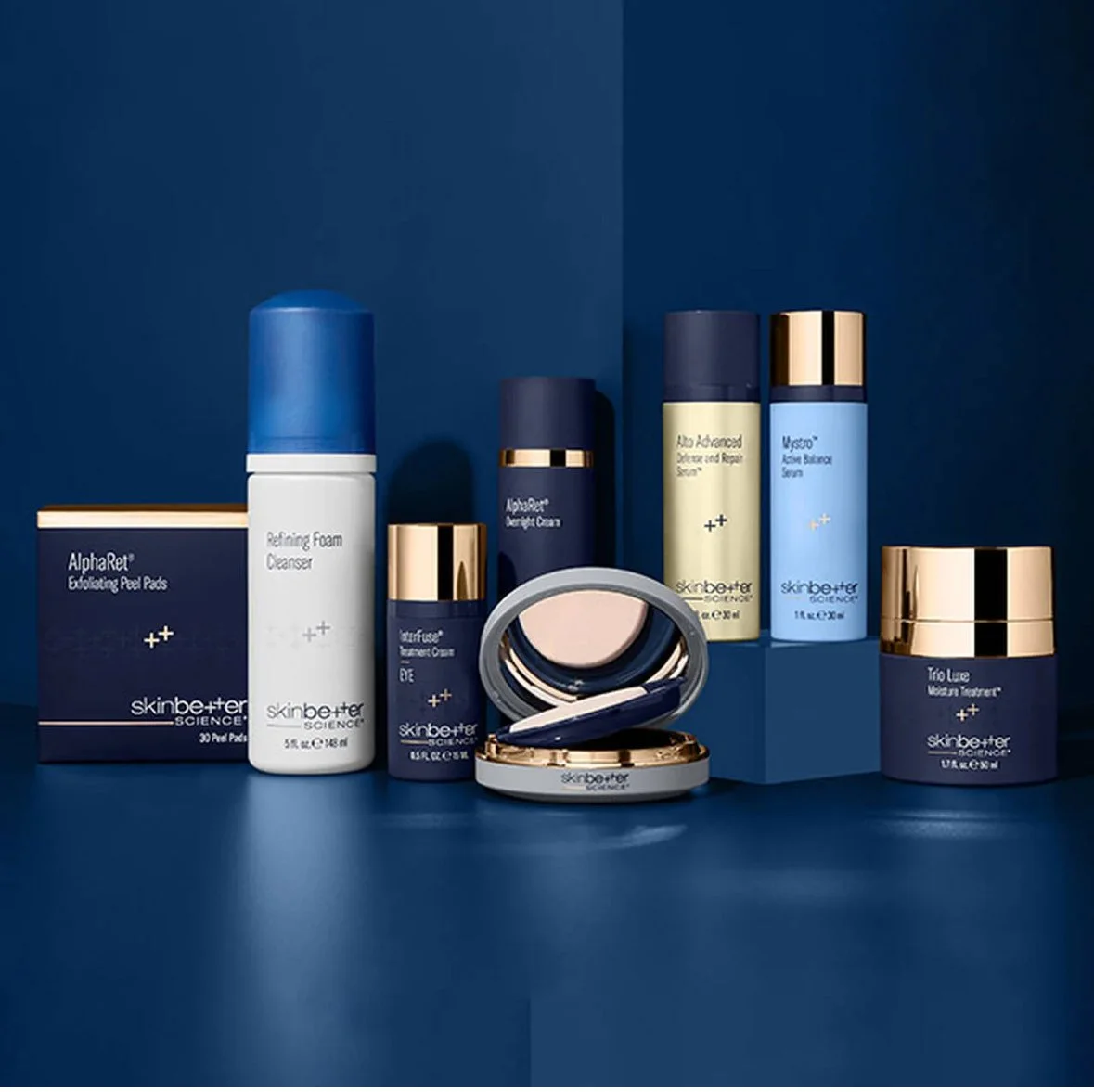 Collection of skincare products, including cleansers, toners, moisturizers, and treatment creams, arranged on a dark blue surface with a matching dark blue background, featuring packaging in white, navy blue, and gold accents.