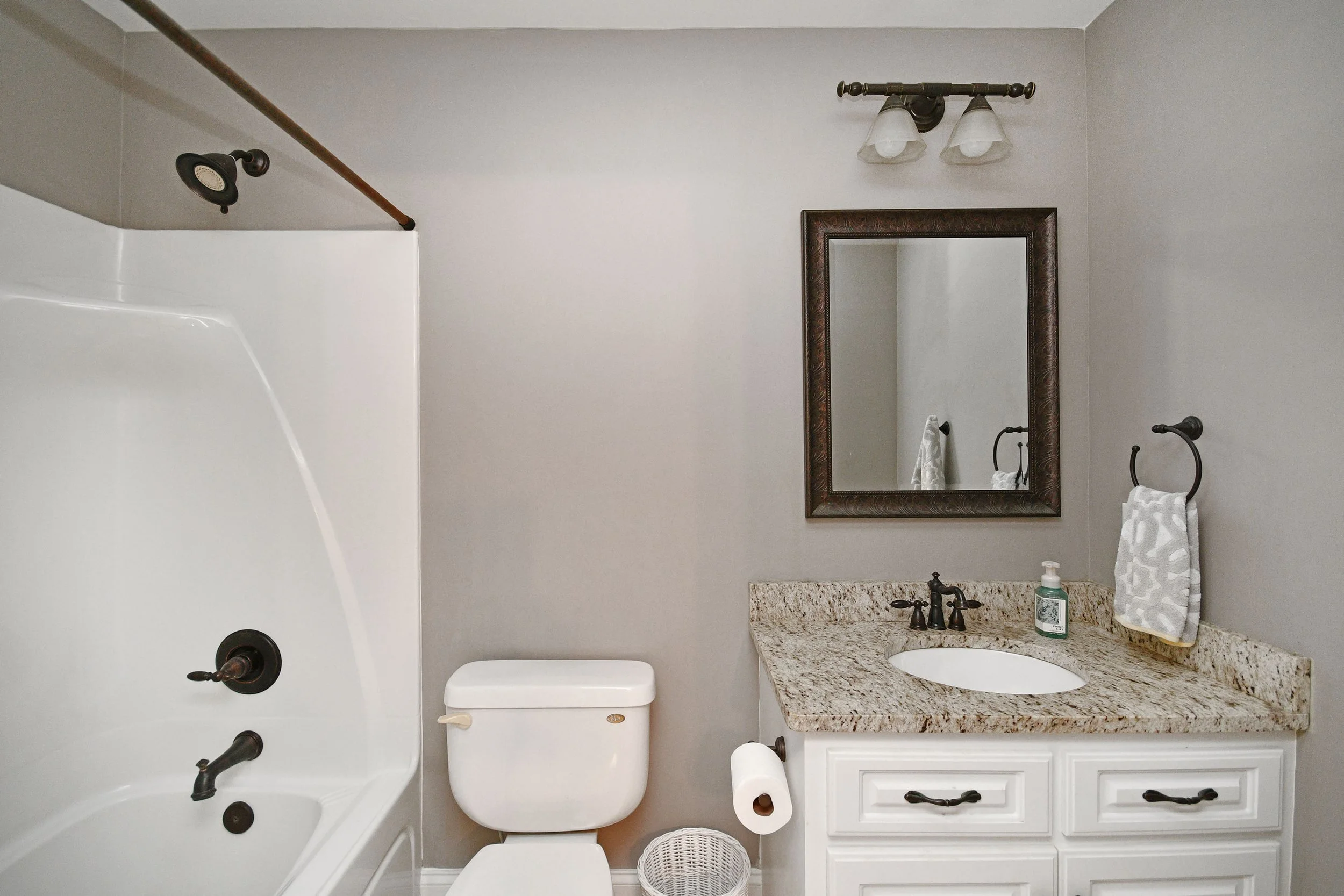 Bathroom with a bathtub, toilet, and a vanity with a mirror and sink. Home for sale in Greenville, SC. Master on Main Level. 4 Bedroom home for sale. Upscale Community. 