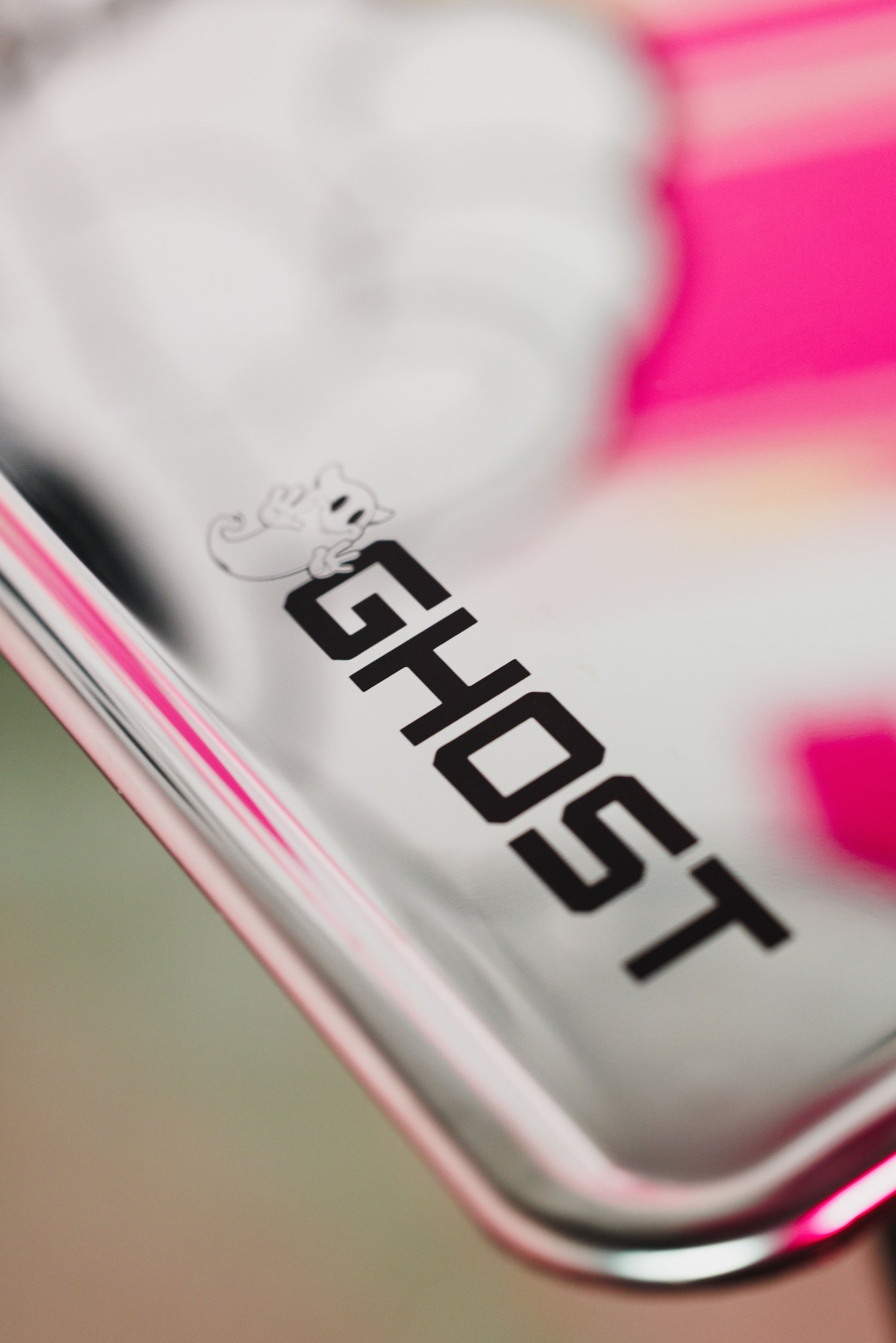 Close-up of a reflective surface with the word 'GHOST' and a small ghost illustration in black text on a metallic background.
