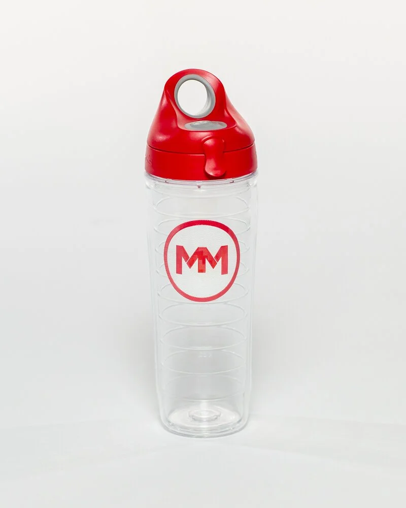 Clear plastic bottle with a red lid and a circular logo featuring the letters 'MM' in red on a white background.