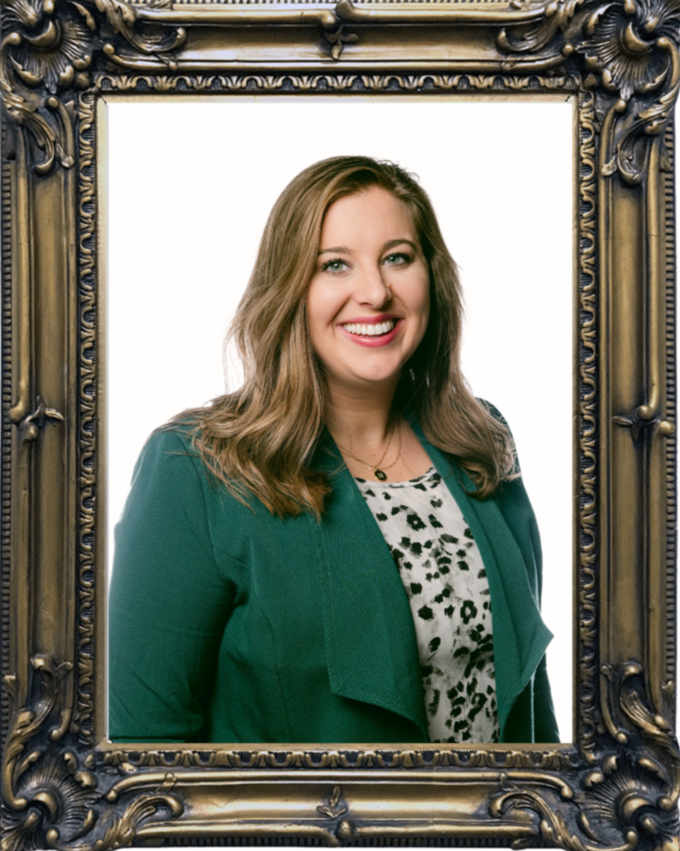 Framed portrait of Hannah Asprodites wearing a green blazer and black and white blouse standing against a plain background.