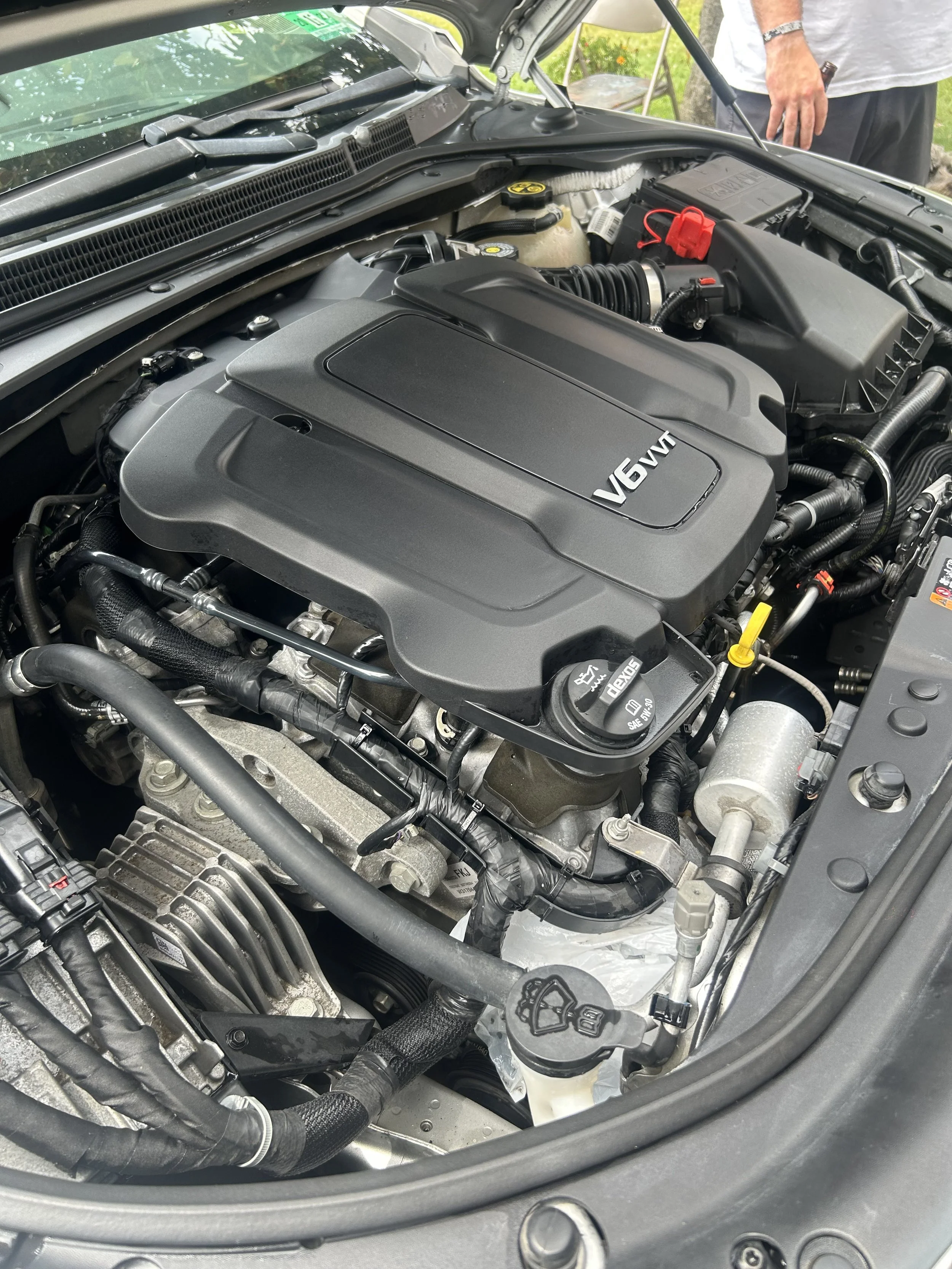 Close-up view of a clean V6 VVT engine in a modern car engine bay with visible components and fluid caps.