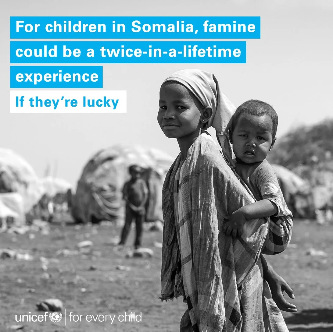 Young Somali girl carrying infant in displacement camp, social impact campaign for UNICEF by story agency STORO