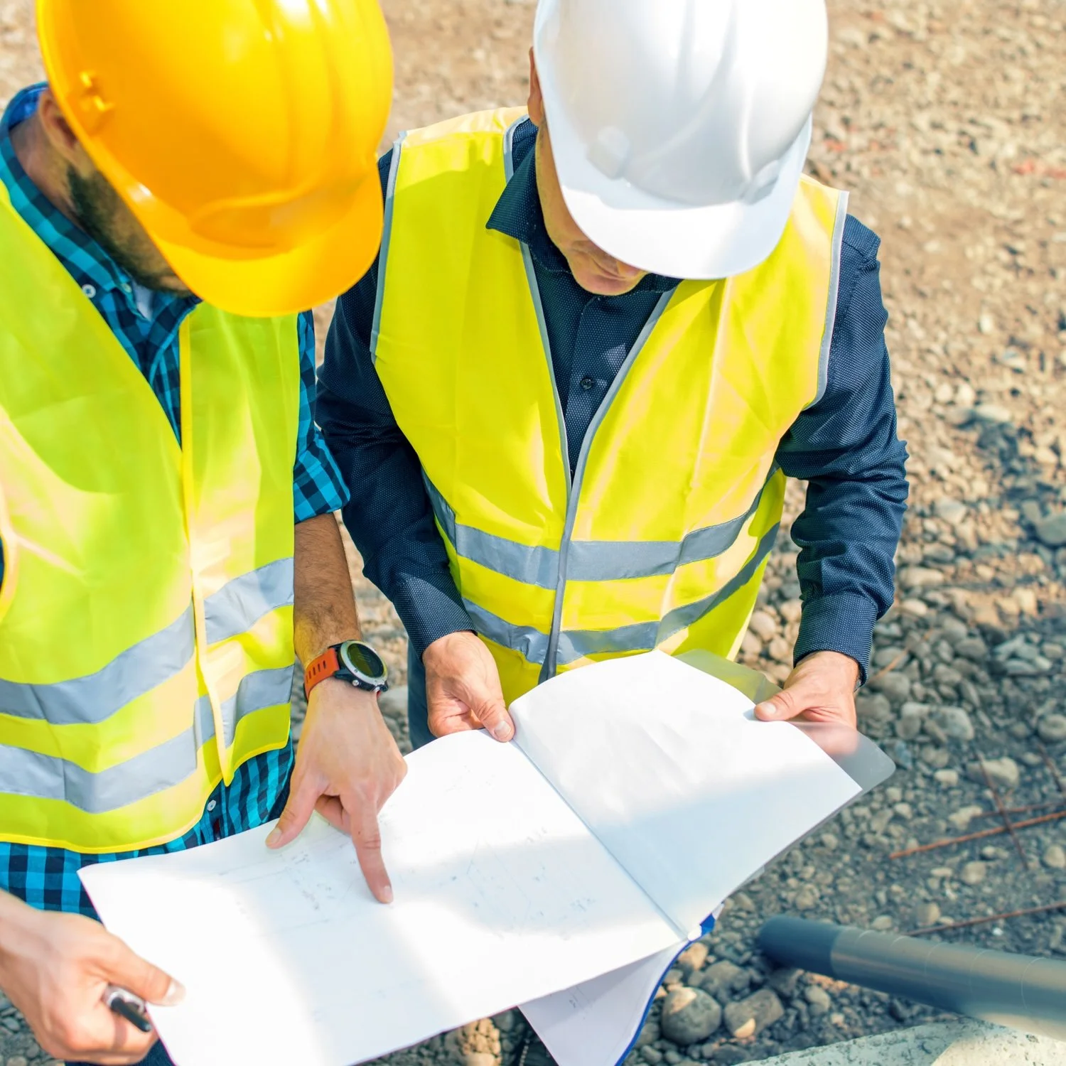 Construction project managers reviewing project plans and jobsite documentation to coordinate commercial and industrial mechanical insulation projects.