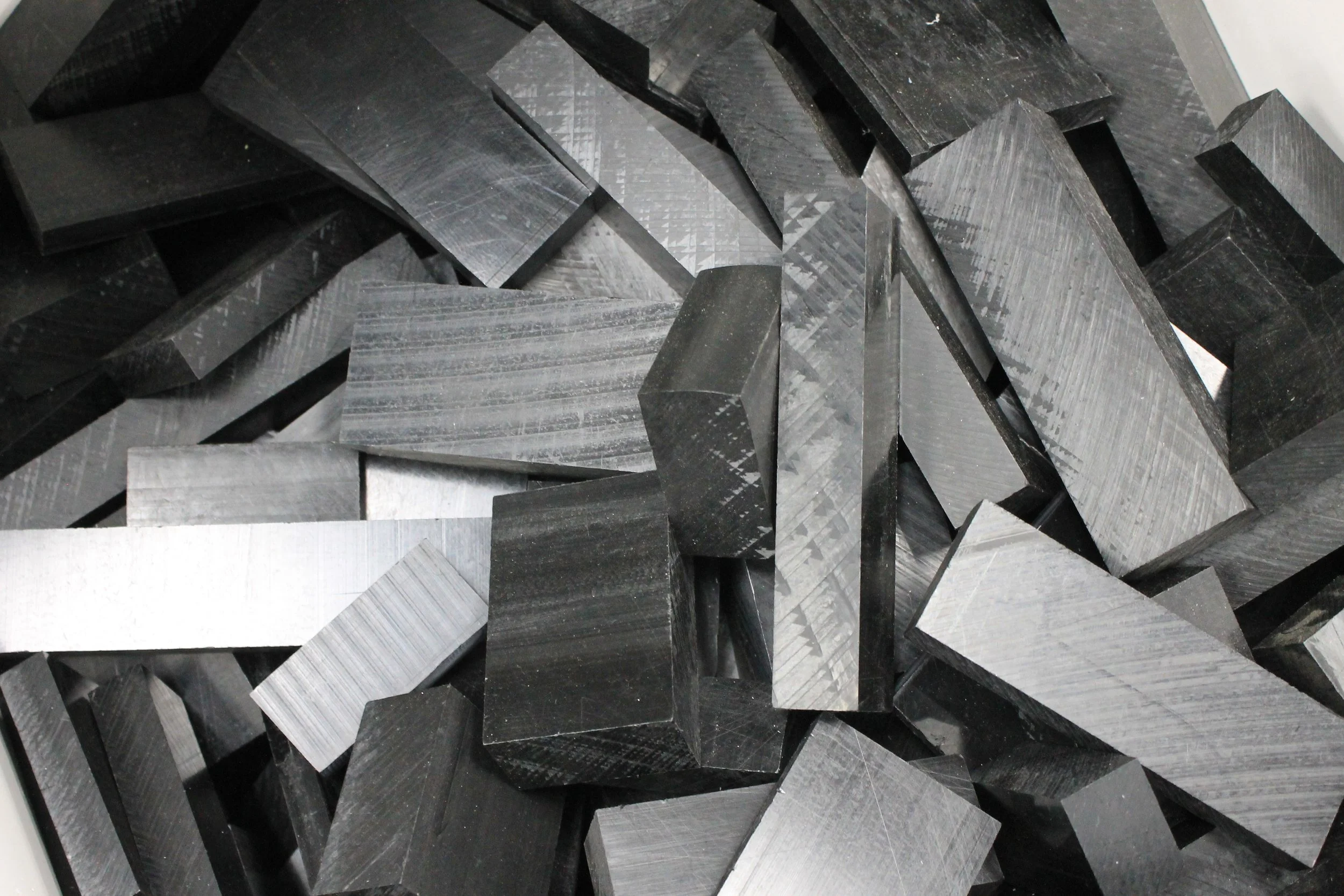 Close-up of numerous black and gray geometric-shaped blocks with a textured surface.