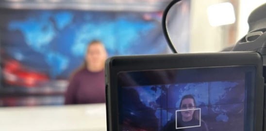 A behind the scenes shot of Melissa playing a news broadcaster in a new short film.