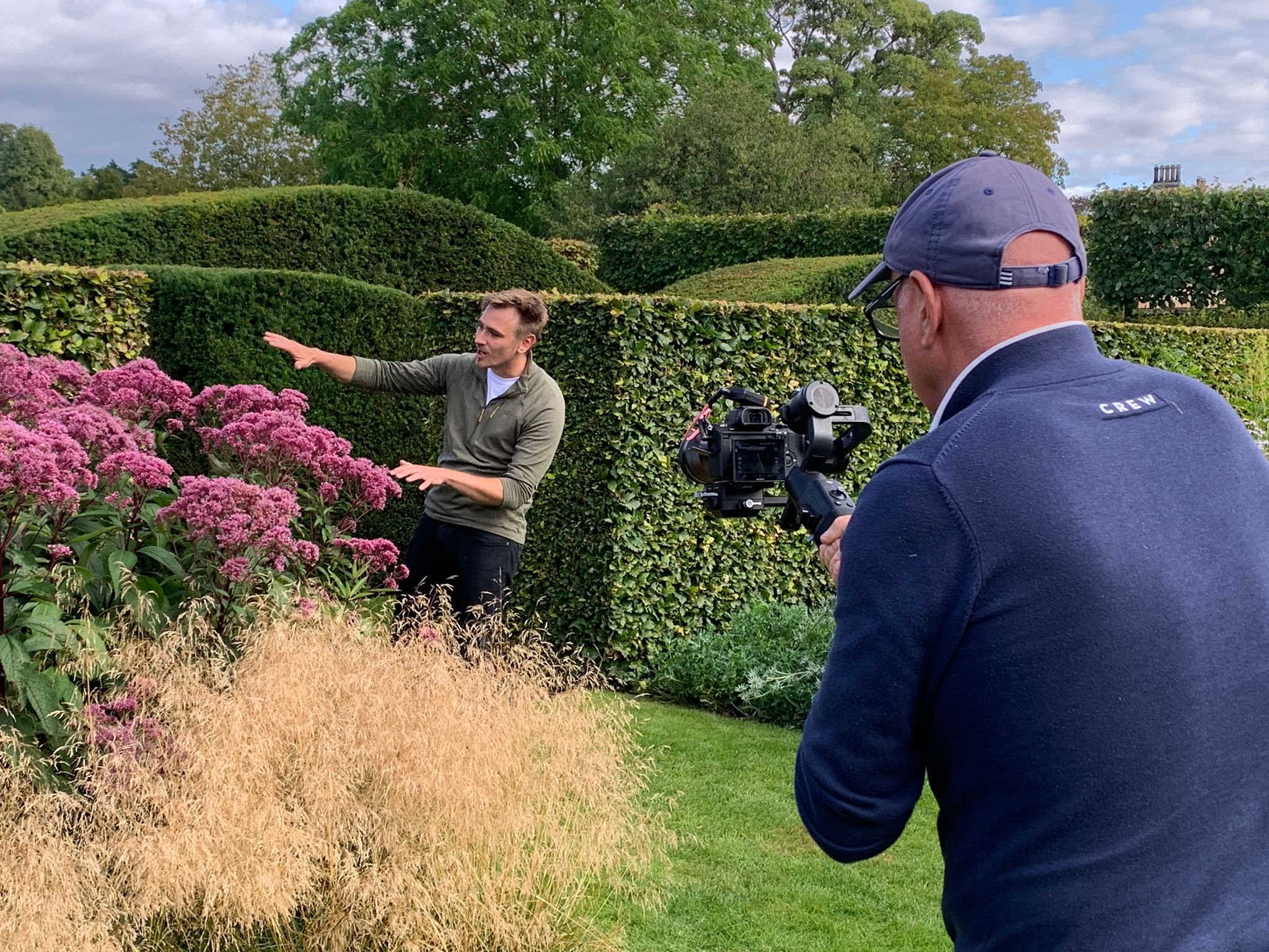 Gardeners' World presenter Jamie Butterworth filming a piece to camera in a garden