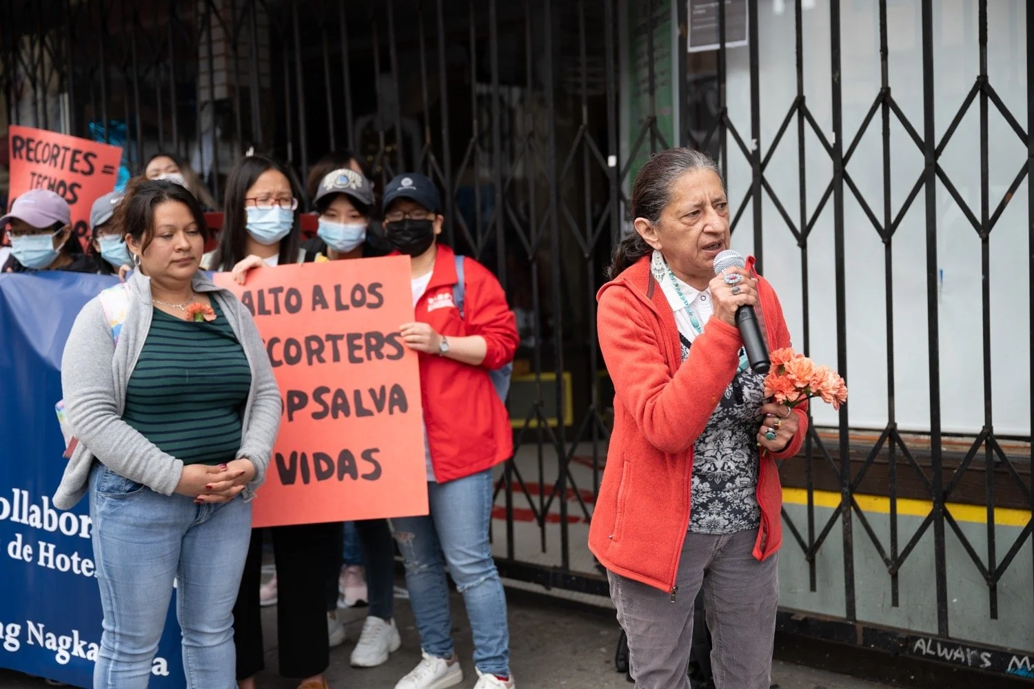 Scenic view of rolling green hills in foreground with a mountain range in the background, under a clear sky.