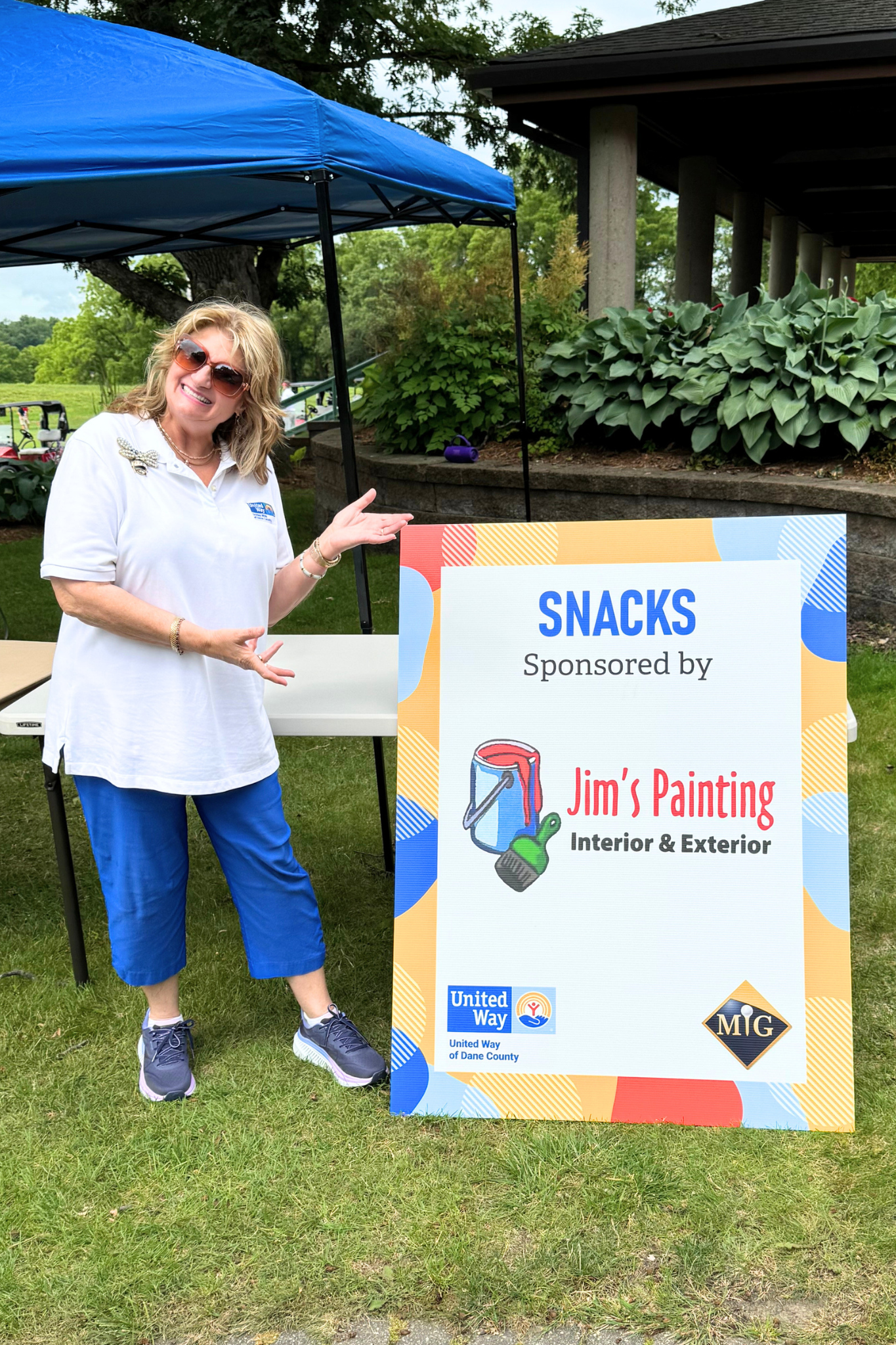 Karen with Jim's Painting Sign.png
