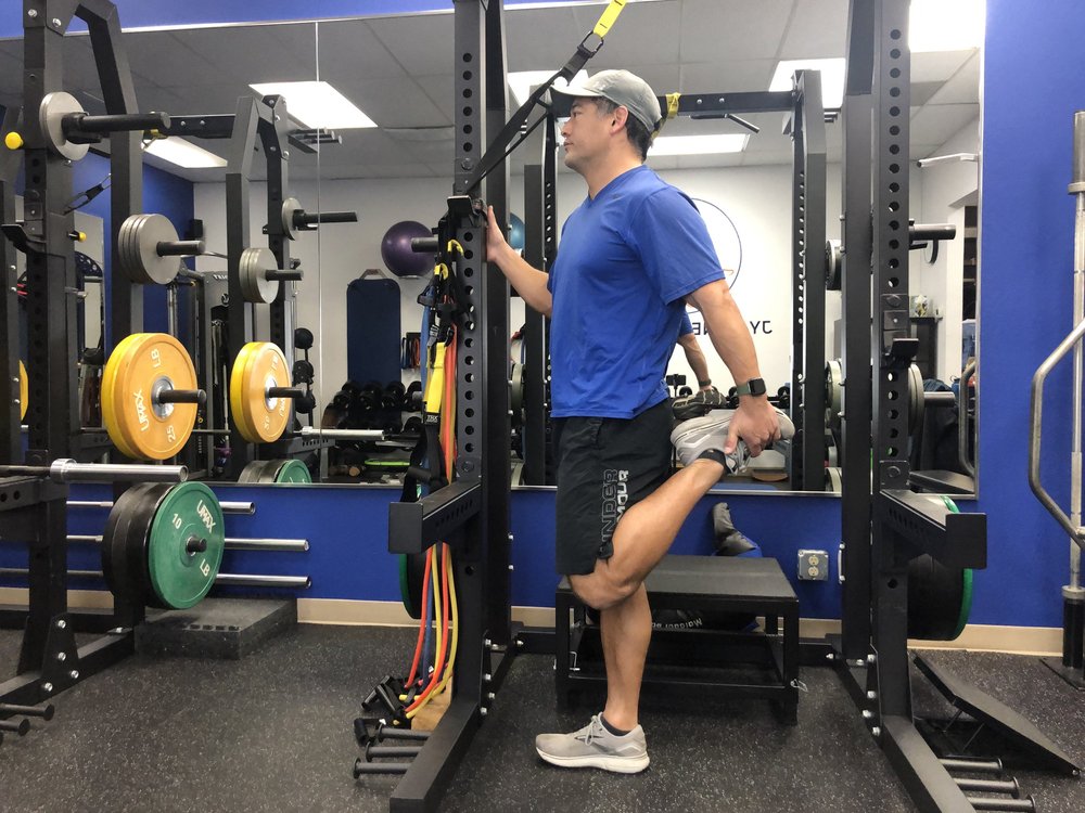 Standing quad stretch with full knee flexion.
