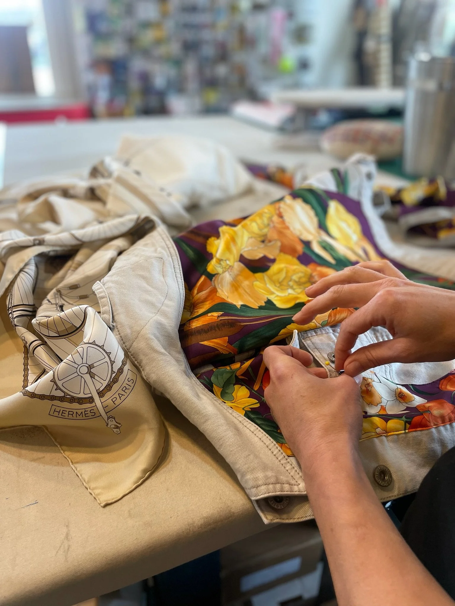 Seamstress close up hand stitching jacket