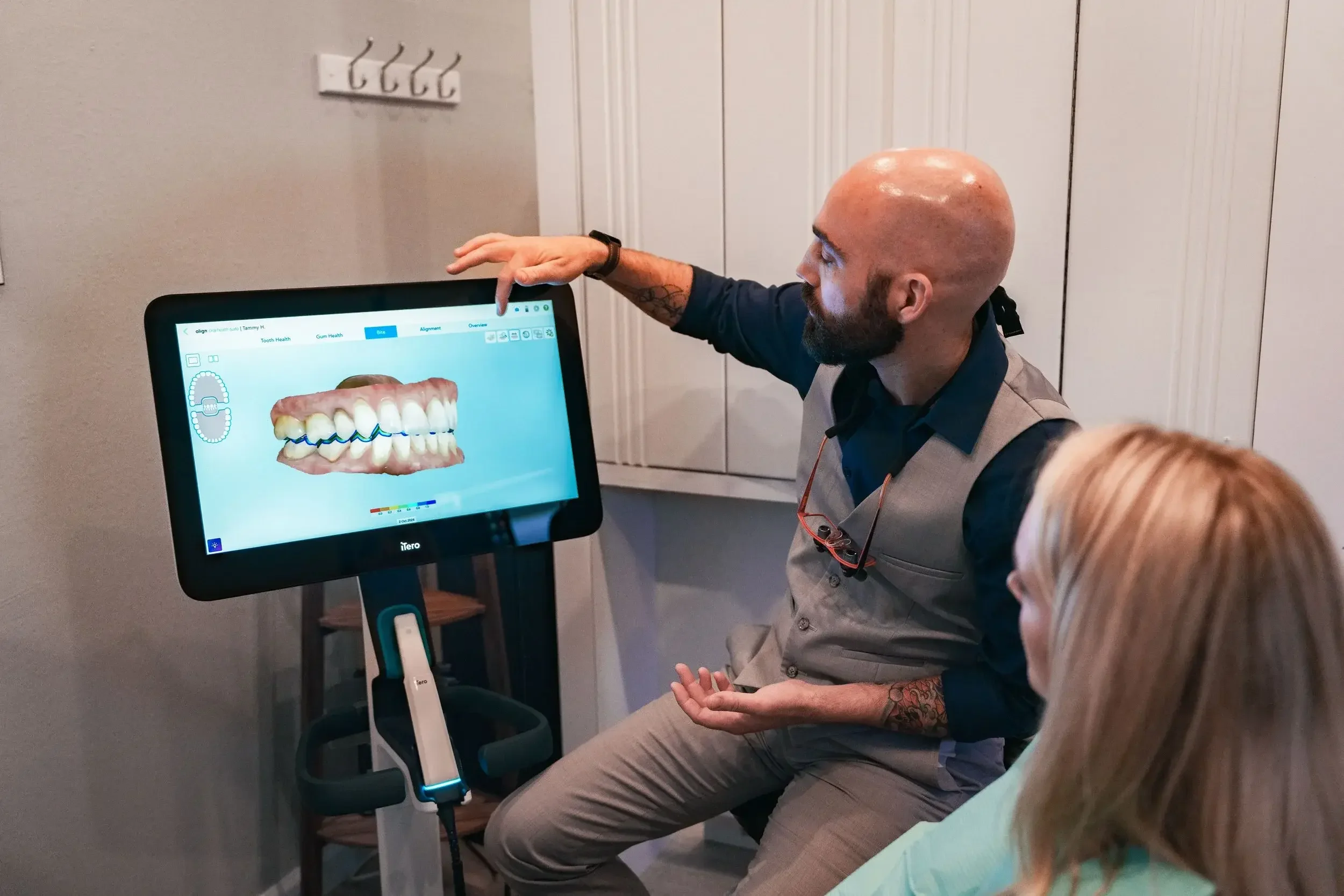 Dentist explaining dental scan on monitor to patient