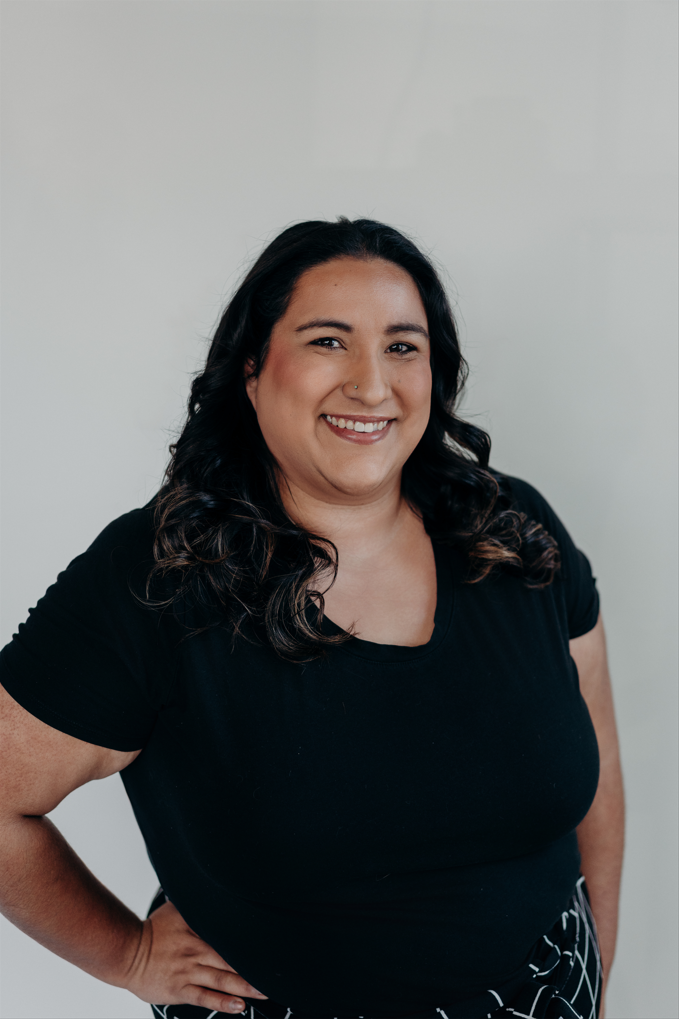 Professional headshot of Elena Torres, Owner, a smiling woman with dark curly hair wearing a black shirt, representing Torres and Co Health Plansin Denver.