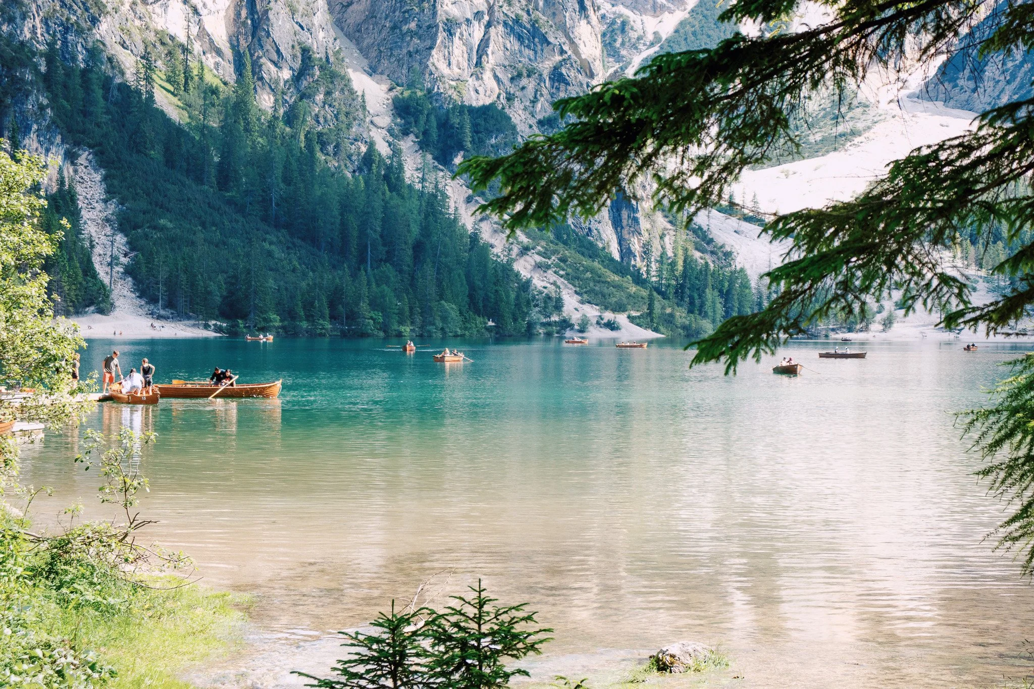 Scenic mountain lake with boats and pine trees