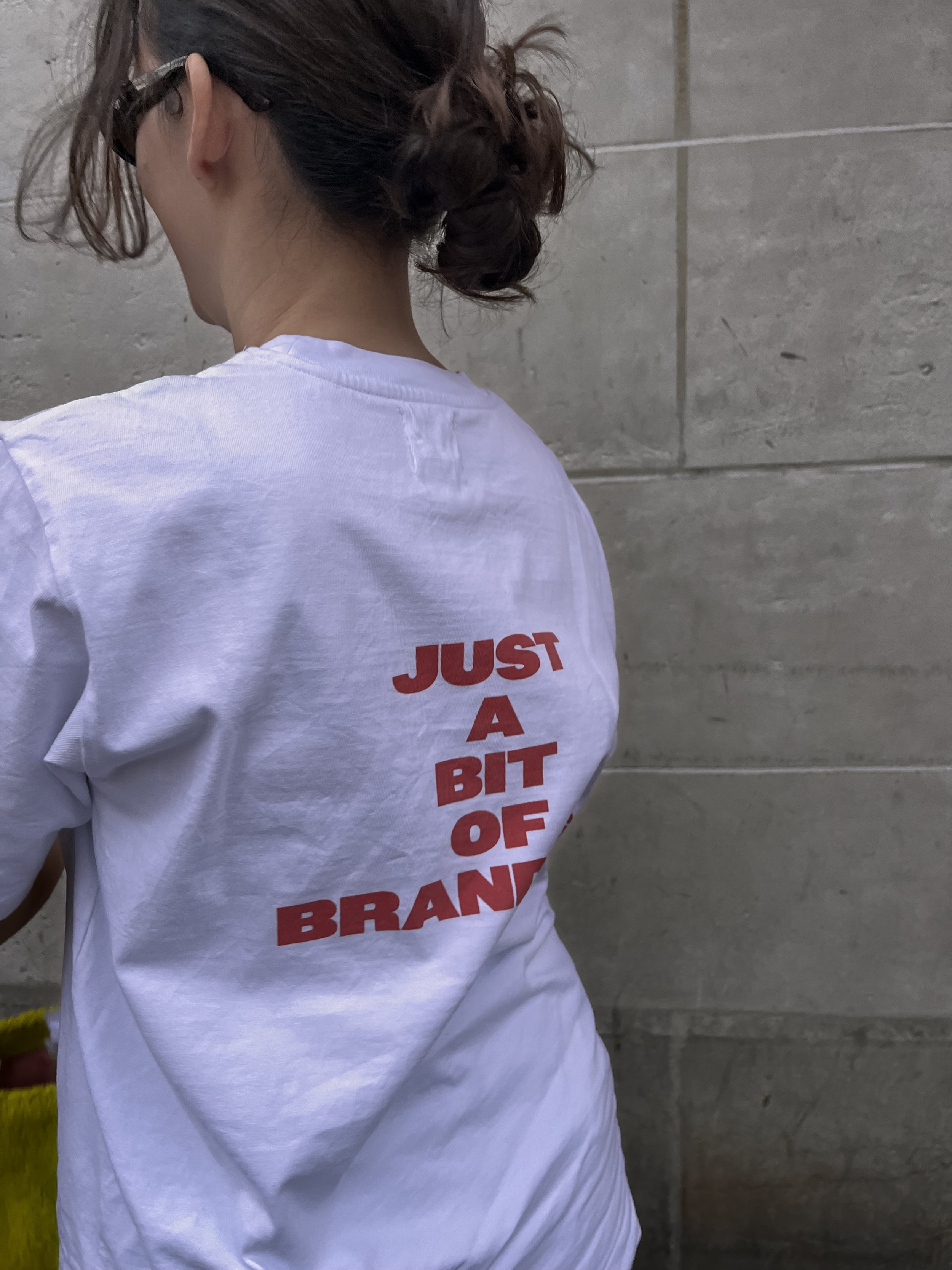 Photo de dos d’un mannequin avec un t-shirt blanc avec écrit ‘Just A bit Of Branding’
