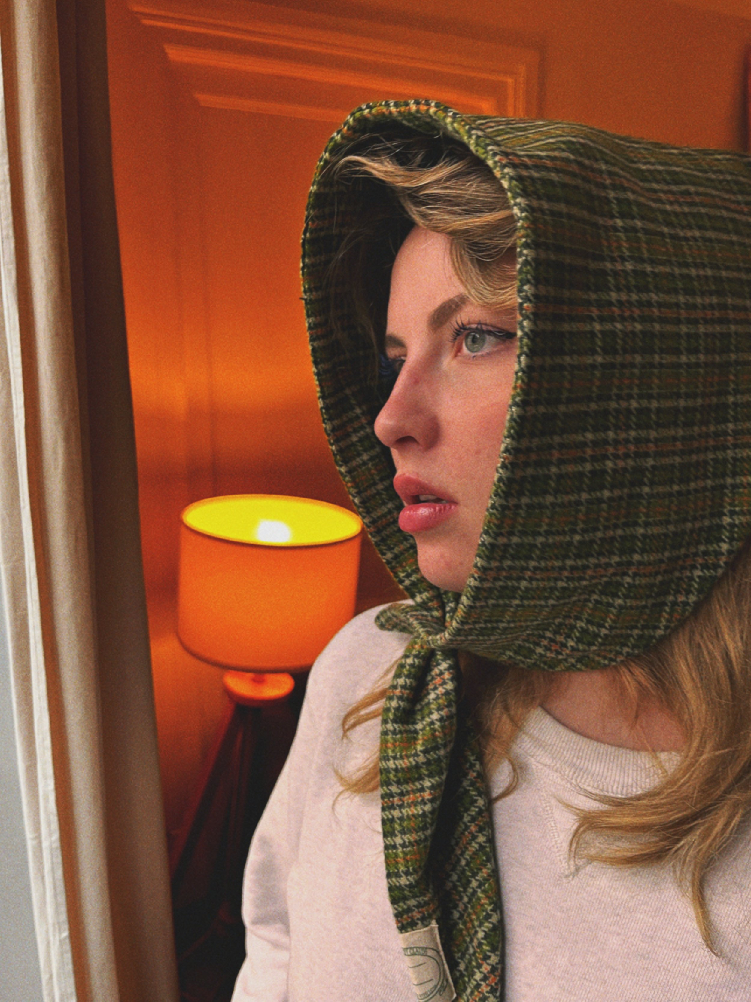 Photo du visage d’une femme entouré d’un foulard en laine à carreaux noué
