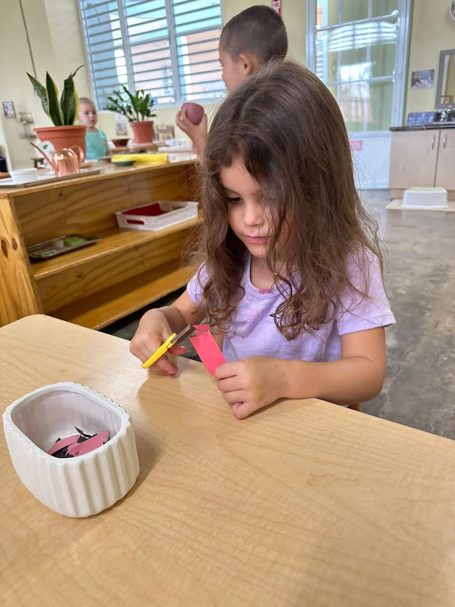 niña recortando papel