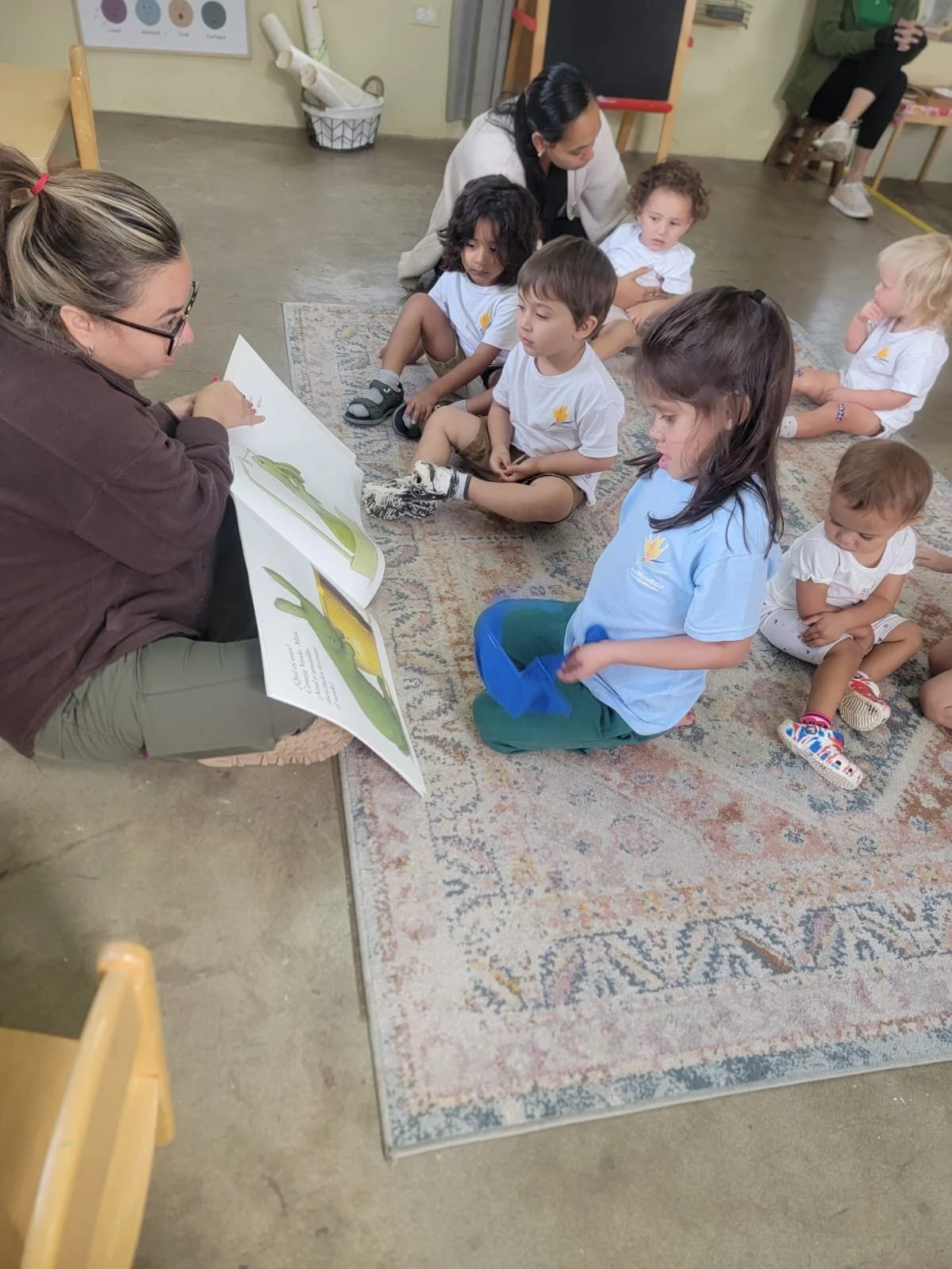 profesora mostrando un libro a estudiantes
