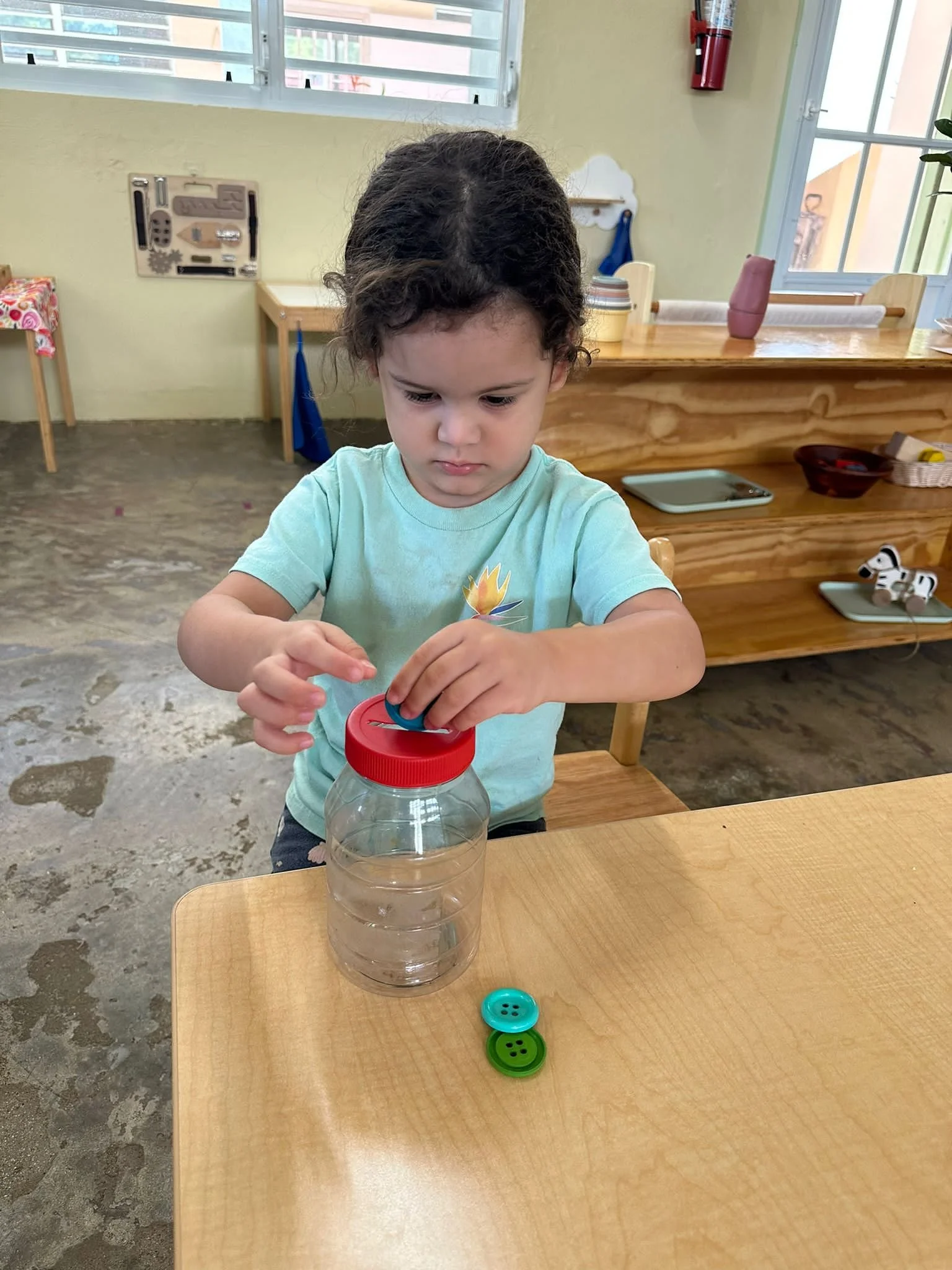 niña introduciendo piezas en una alcancía