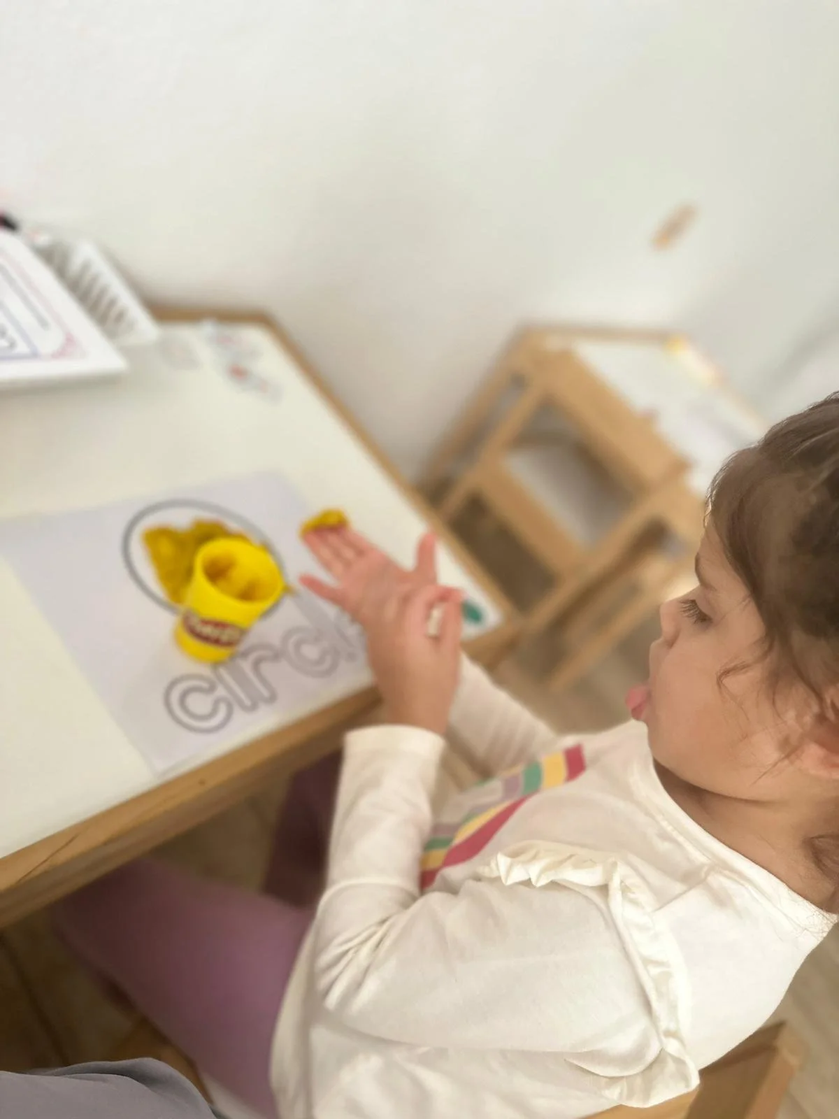 niña pintando con plastilina