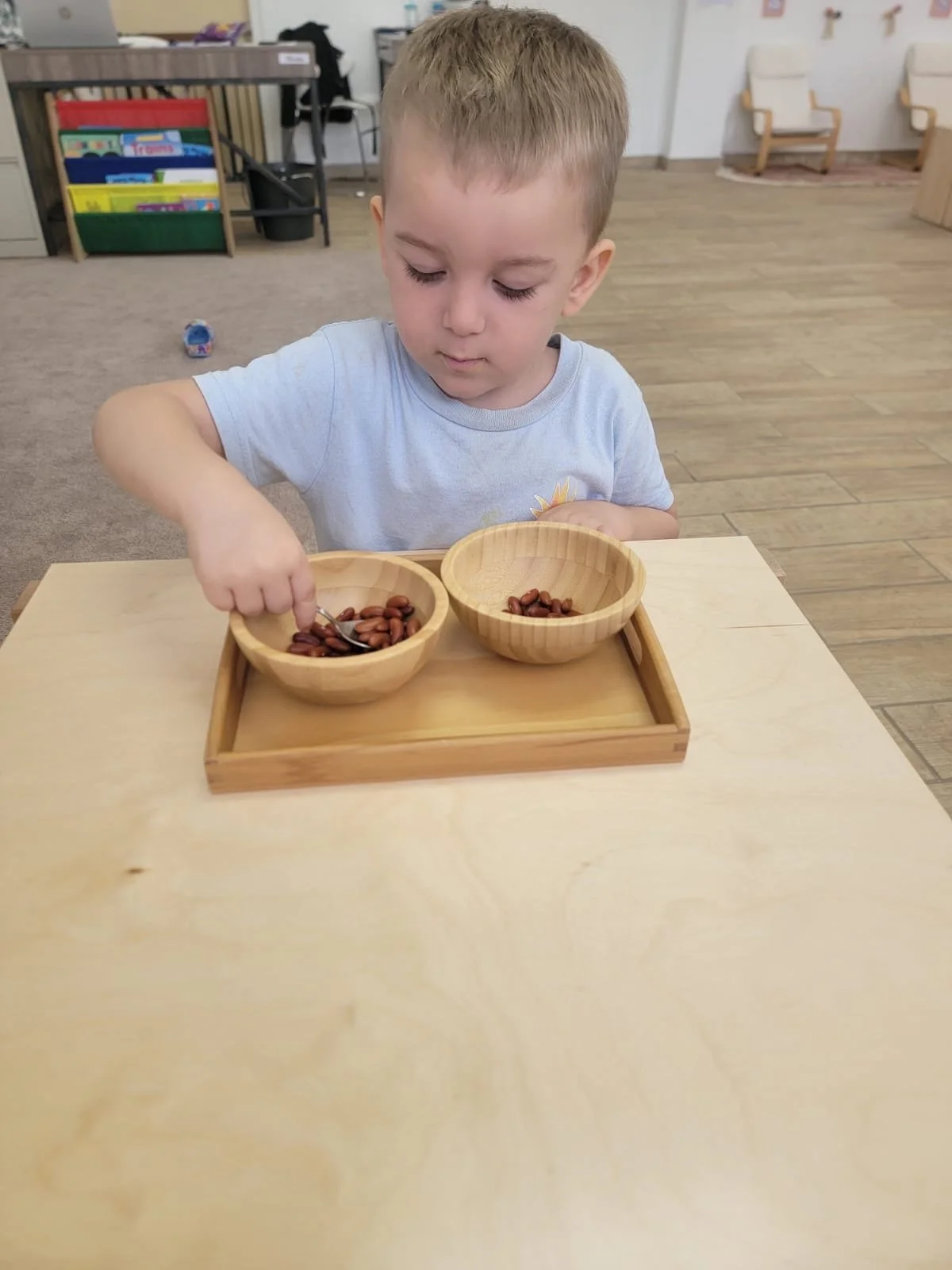 niño con 2 platos y objetos y frijoles adentro