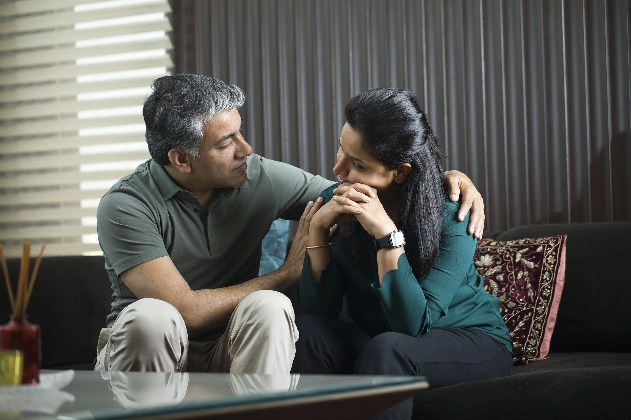 A couple sitting together having an honest conversation about criticism in their relationship, showing what reconnection looks like when both partners are present.