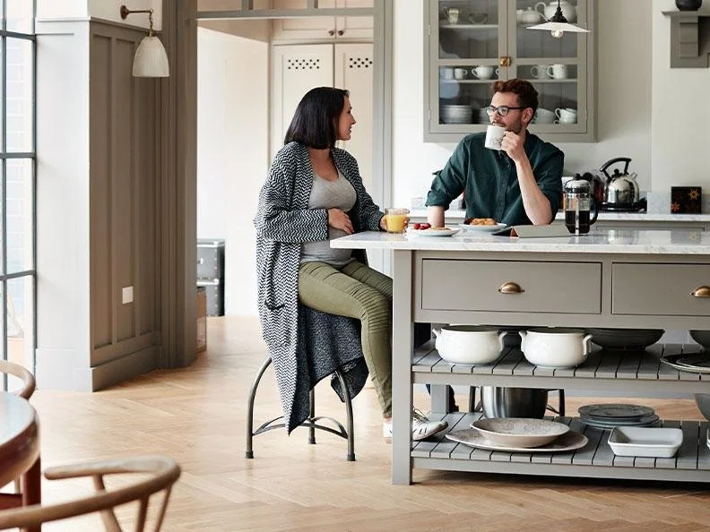 Expectant couple having a quiet conversation at home before welcoming their baby.