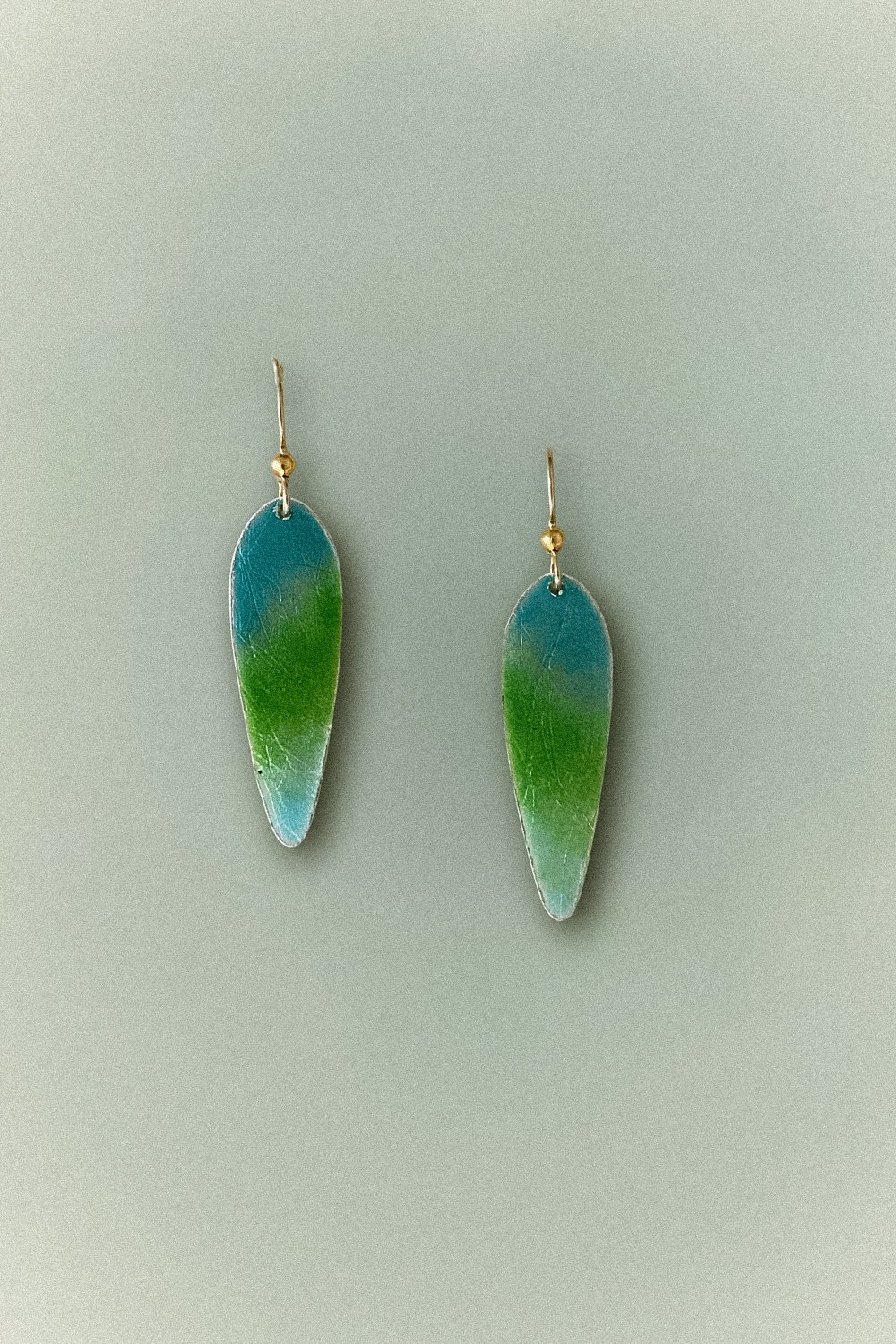 Ocean Teardrop Enamel Earrings featuring blue and green hues on teardrop-shaped fine silver, handcrafted in Linda Lewis's Avila Beach studio