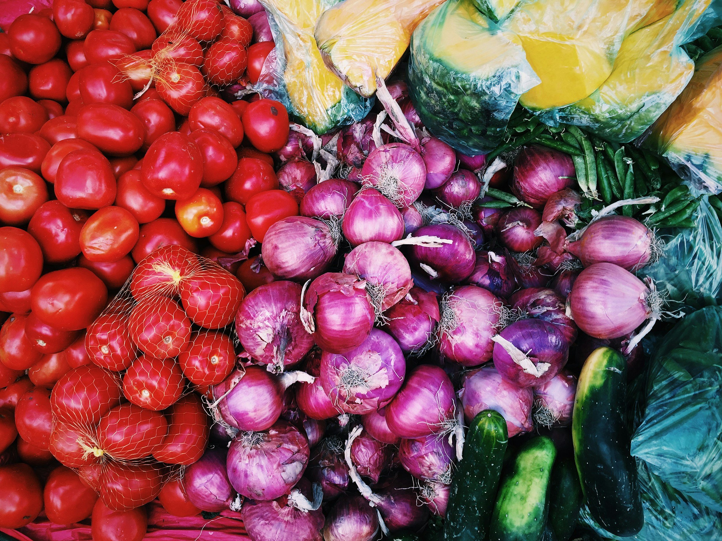 Fresh tomatoes, red onions, cucumbers, and other produce sourced from BIPOC farmers, supporting Saba Community Food Alliance’s ethical distribution of healthy, farm-to-table food in the Bay Area.