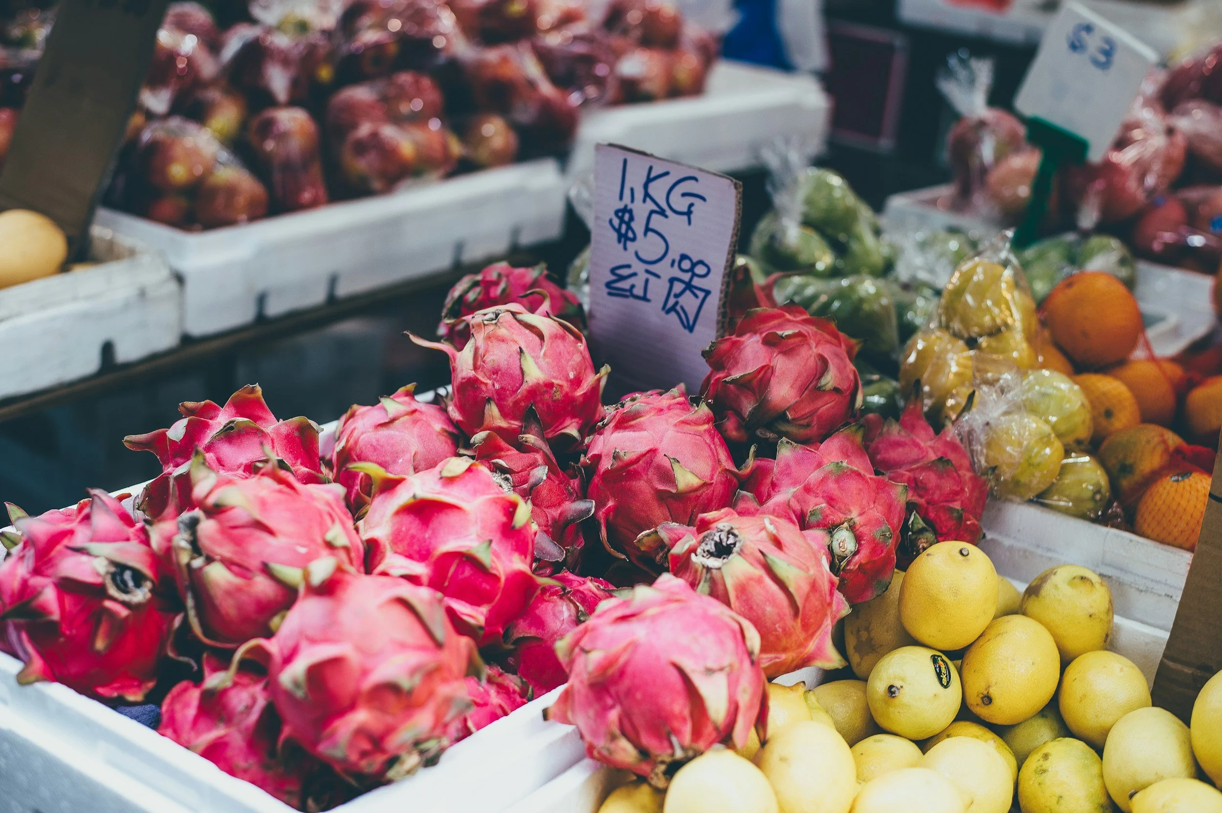 A market display of vibrant dragon fruit and yellow pears, emphasizing the diverse, fresh produce available through Saba Community Food Alliance’s network, supporting BIPOC farmers and ethical sourcing in the Bay Area.