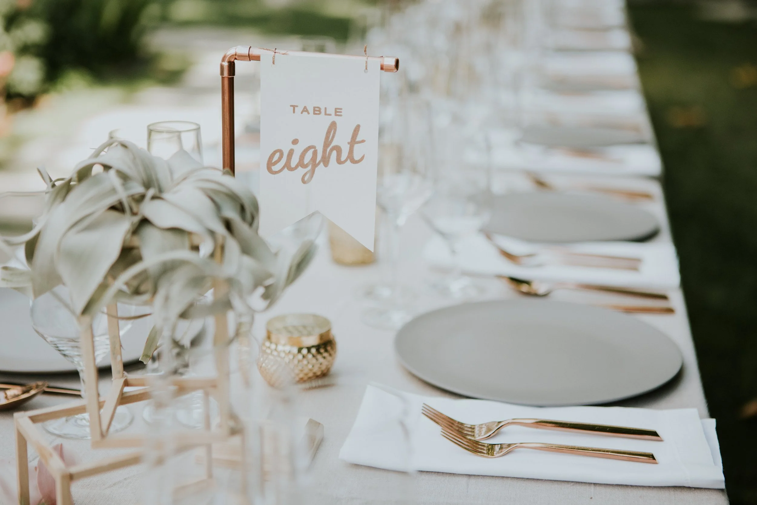 Denver wedding planner stylizing modern wedding tablescape, gold votive candles, airplant centerpieces, minimalistic and contemporary dinnerware