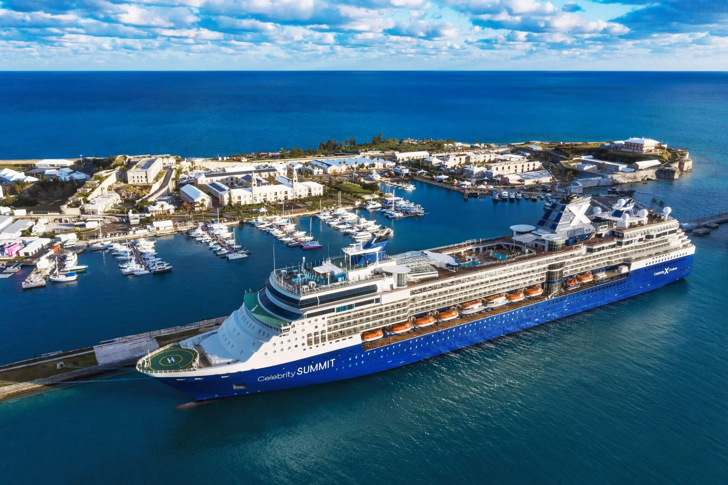 Luxury ocean cruise ship docked at a scenic port, offering world-class dining and cultural experiences with The Three’s Club