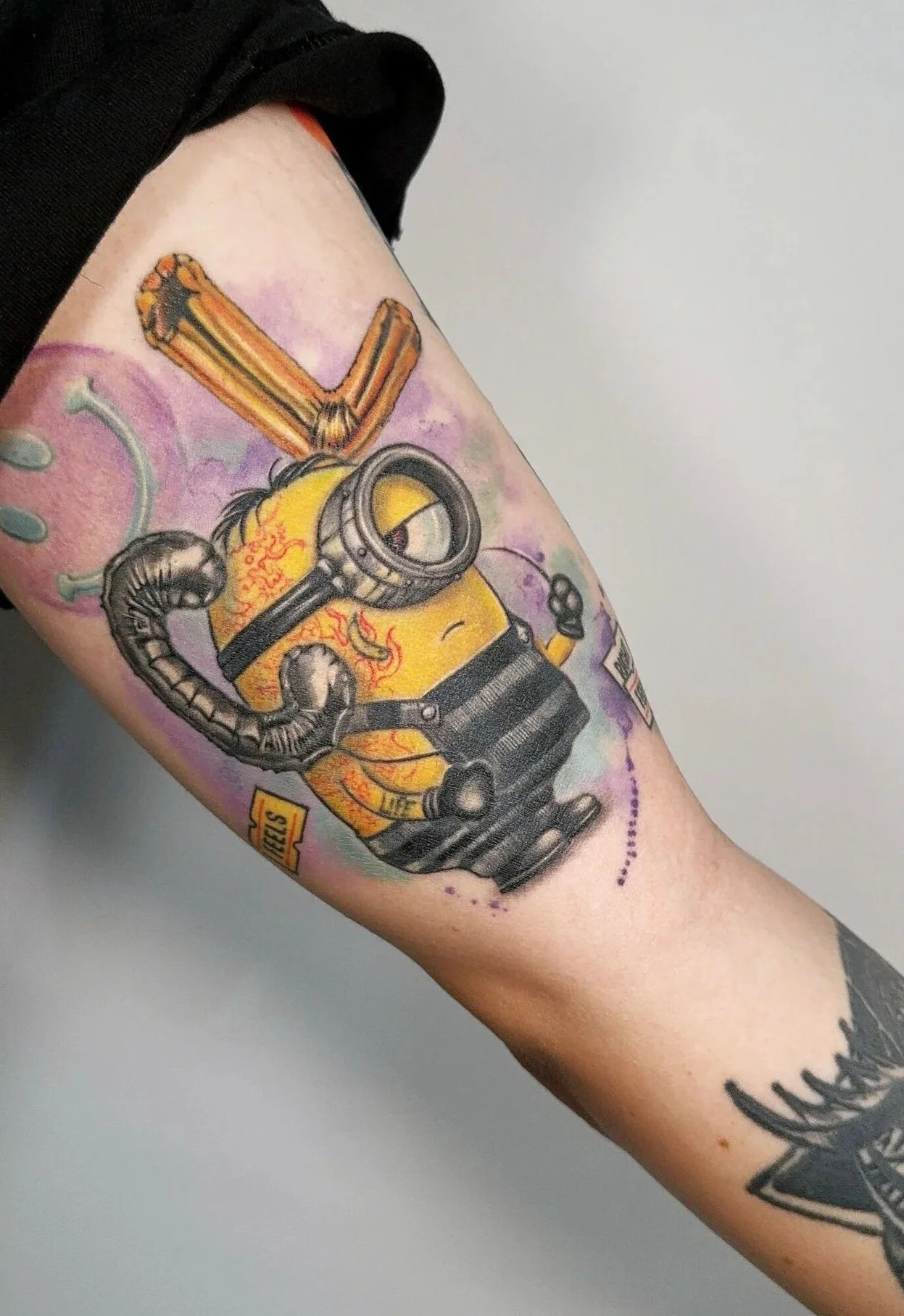 a cartoon minion with robotic arms