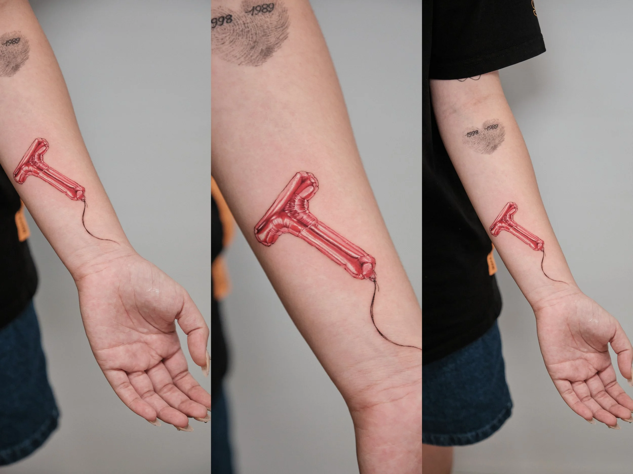 Temporary tattoo of a red hammer on a person's inner forearm.