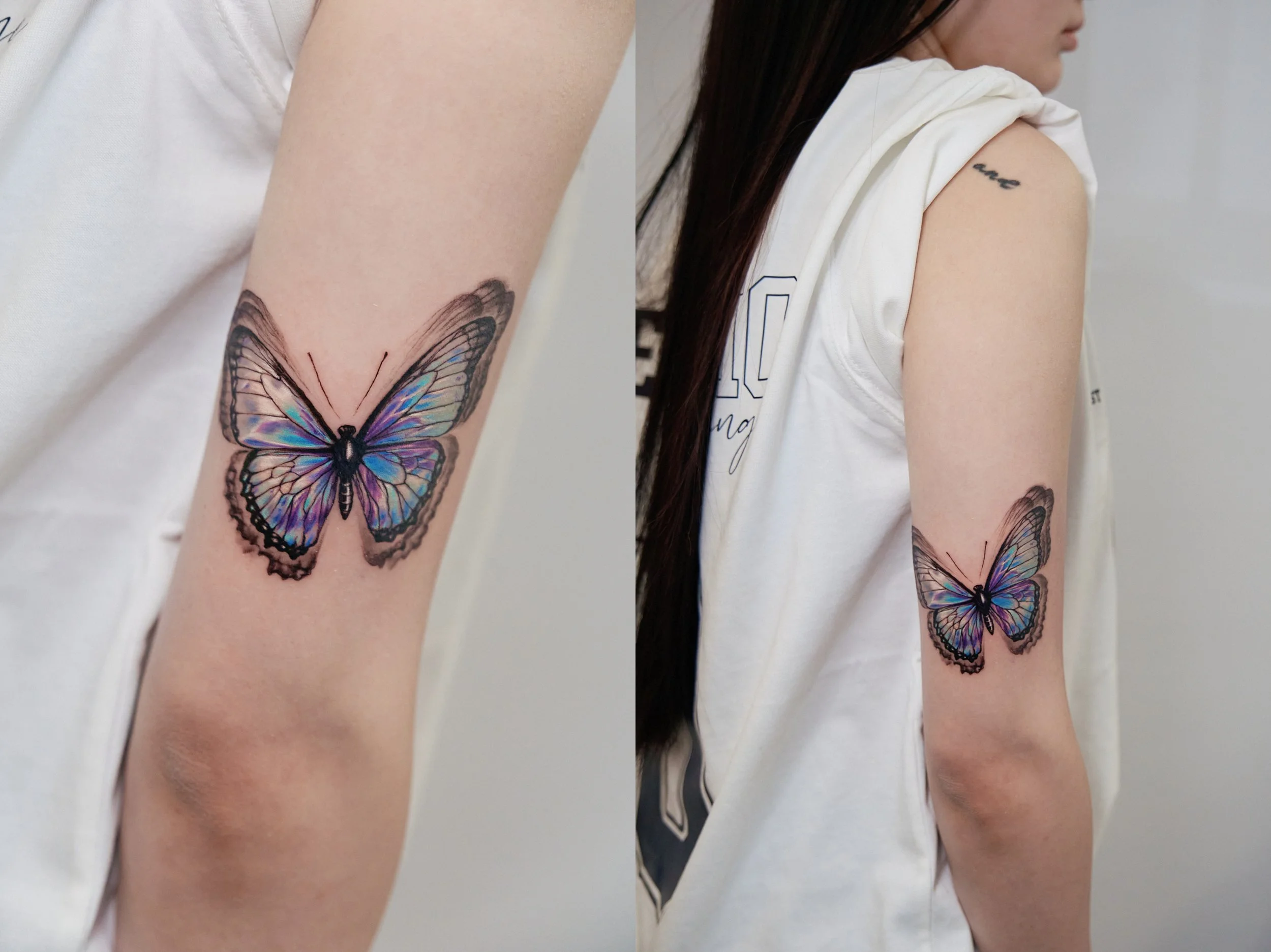 Close-up of a person's upper arm with a colorful butterfly tattoo containing shades of purple, blue, and black.