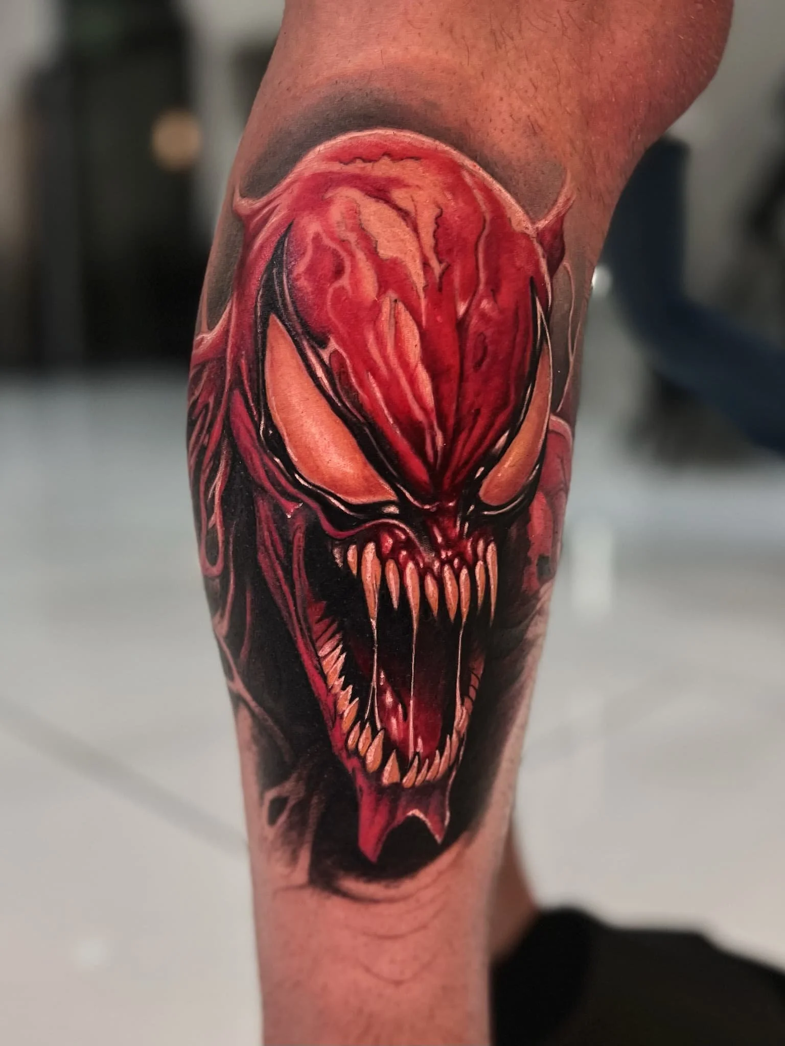 trevor-artist-monstrous-red-black-face-sharp-teeth-arm-tattoo.jpg