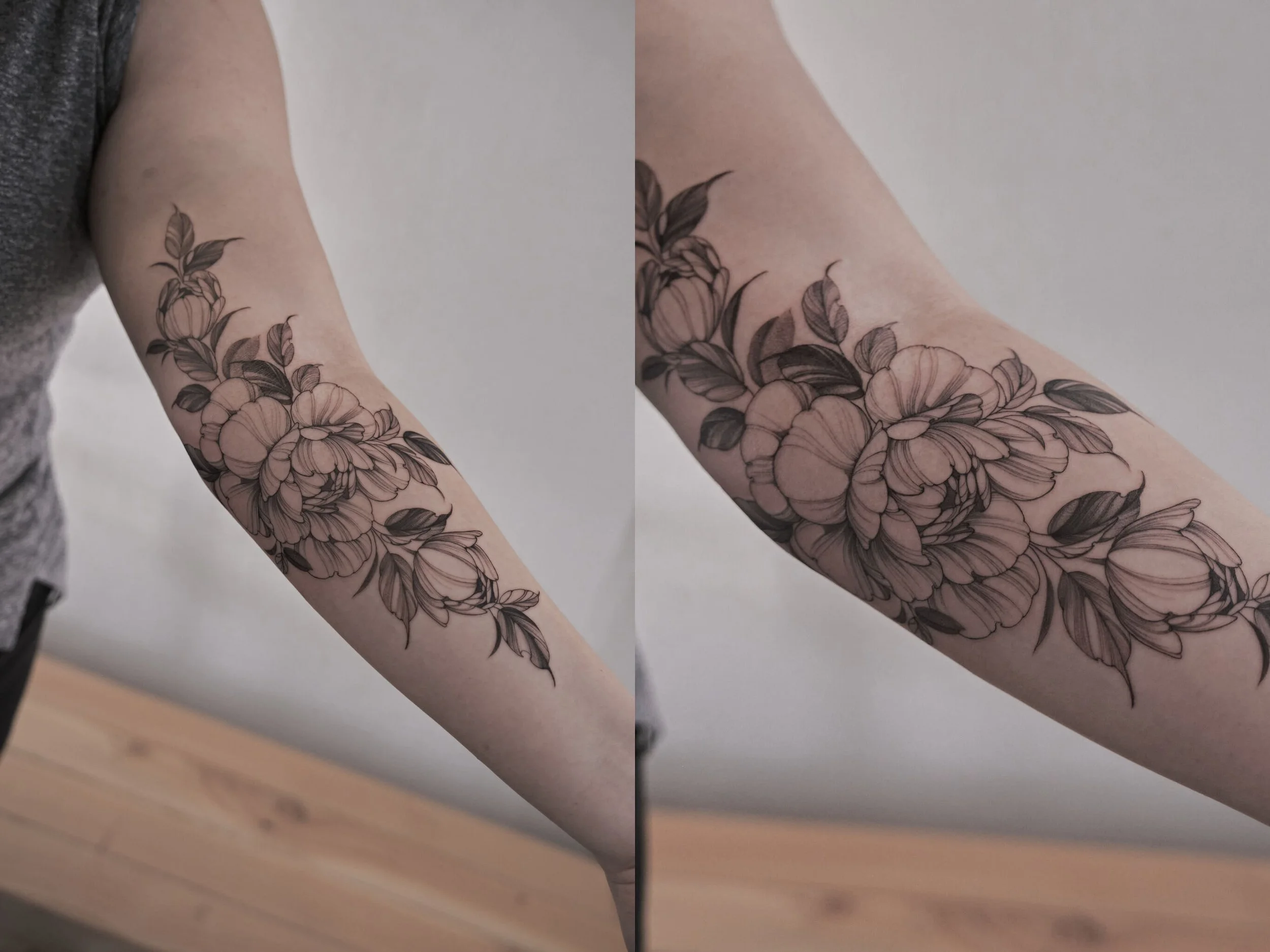 Black and gray floral tattoo on person's forearm, featuring large blossoms and leaves.