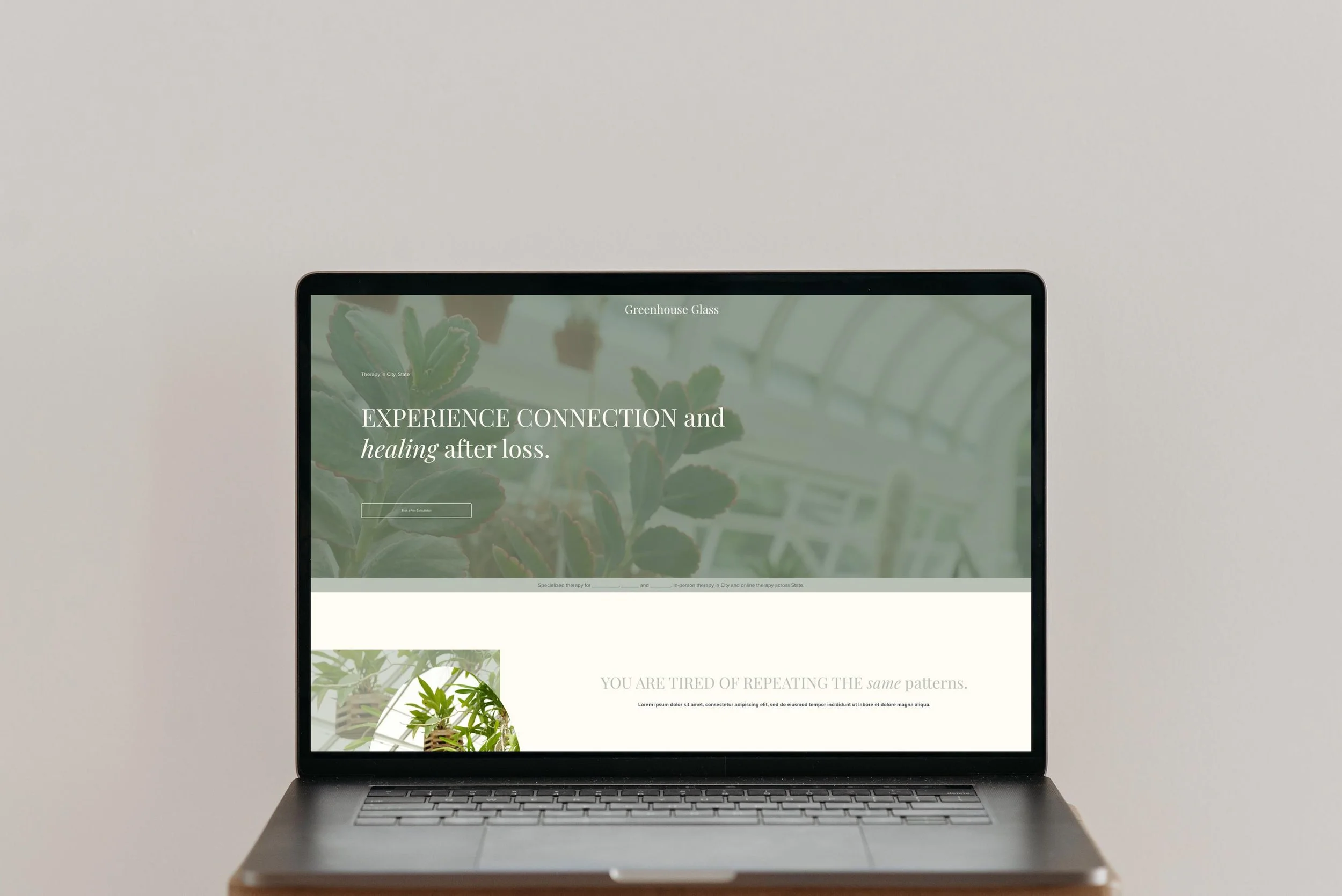 A laptop computer displaying a website about therapy and healing, with greenery in the background, against a plain light-colored wall.