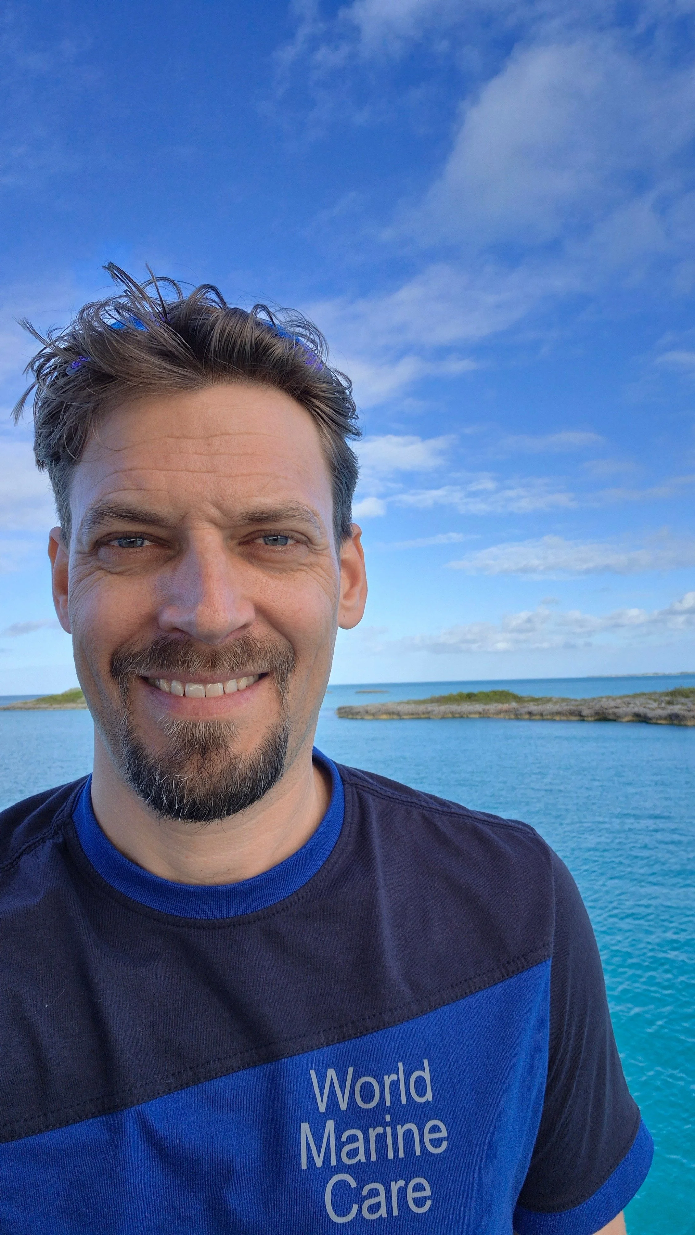 Wybo Overmeer, Marine Electric Engineer on a boat in the Bahamas, wearing the World Marine Care shirt