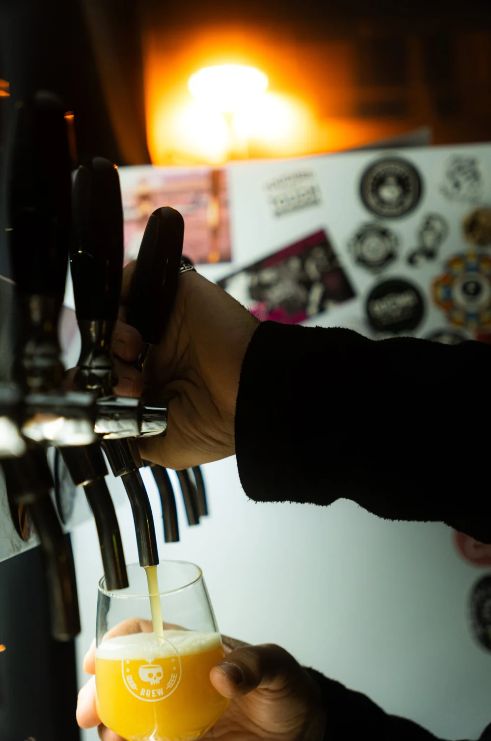 A hand operating a beer tap at High Hops.