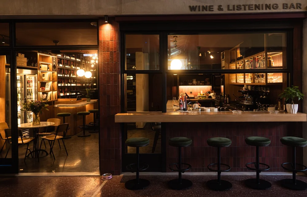 The warmly lit bar and stools inside Strafilo wine bar.