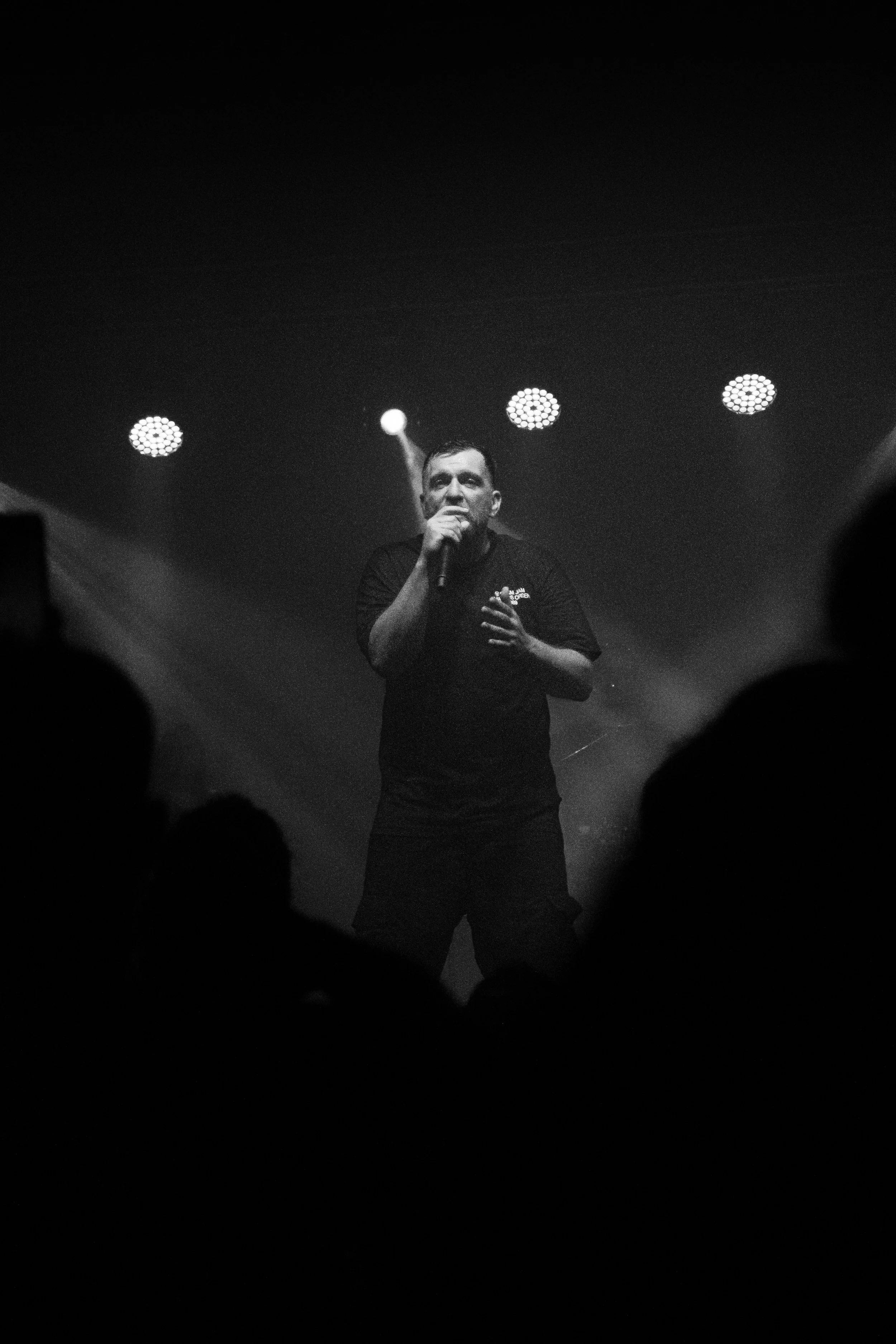 Anser framed by the audience in a black-and-white concert photograph.